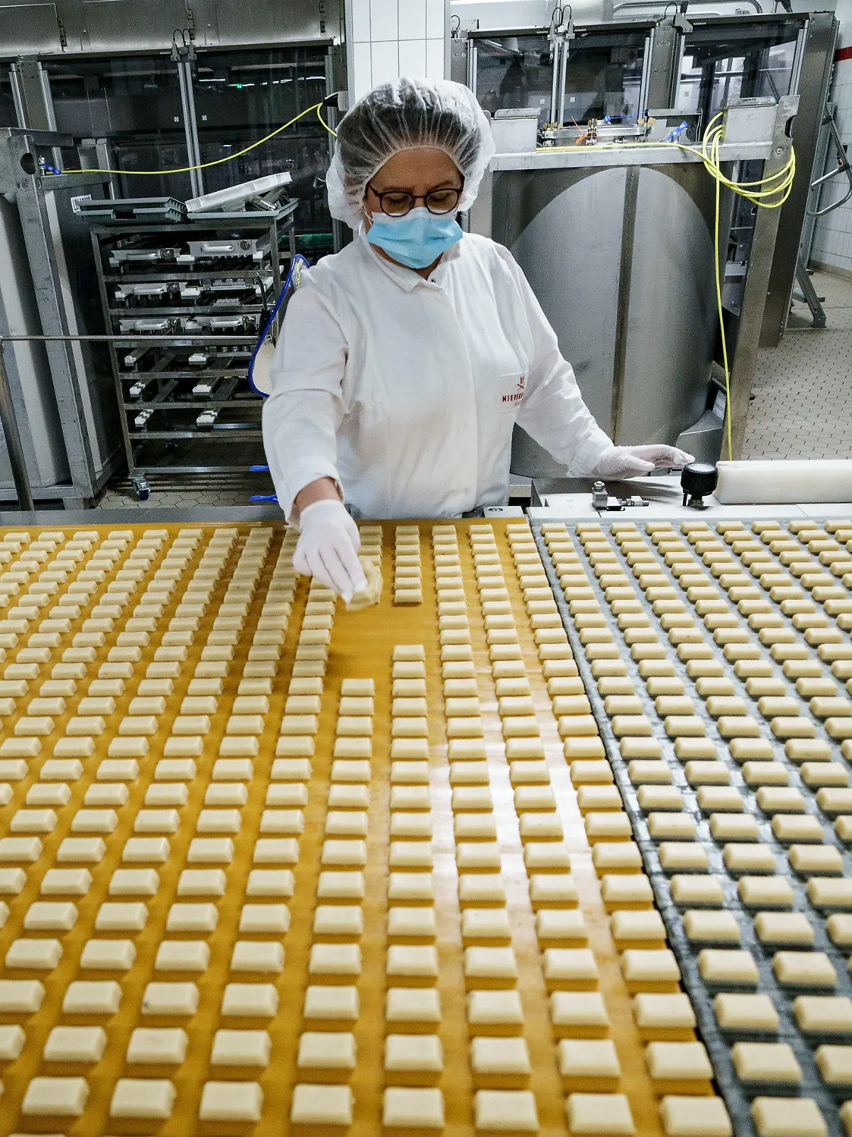 03.11.2021, Schleswig-Holstein, Lübeck: Eine Arbeiterin kontrolliert in einer Produktionsanlage der Firma Niederegger die Form von Marzipanstücken. Bei Niederegger ist die Weihnachtsproduktion in vollem Gang. Foto: Axel Heimken/dpa +++ dpa-Bildfunk +++