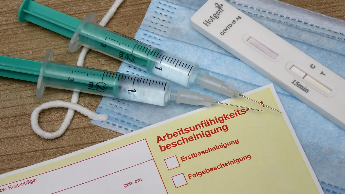 24.09.2021, Borkwalde, Brandenburg, Neben einem Krankenschein liegen Mundschutzmaske, Test Kit und zwei Spritzen.
