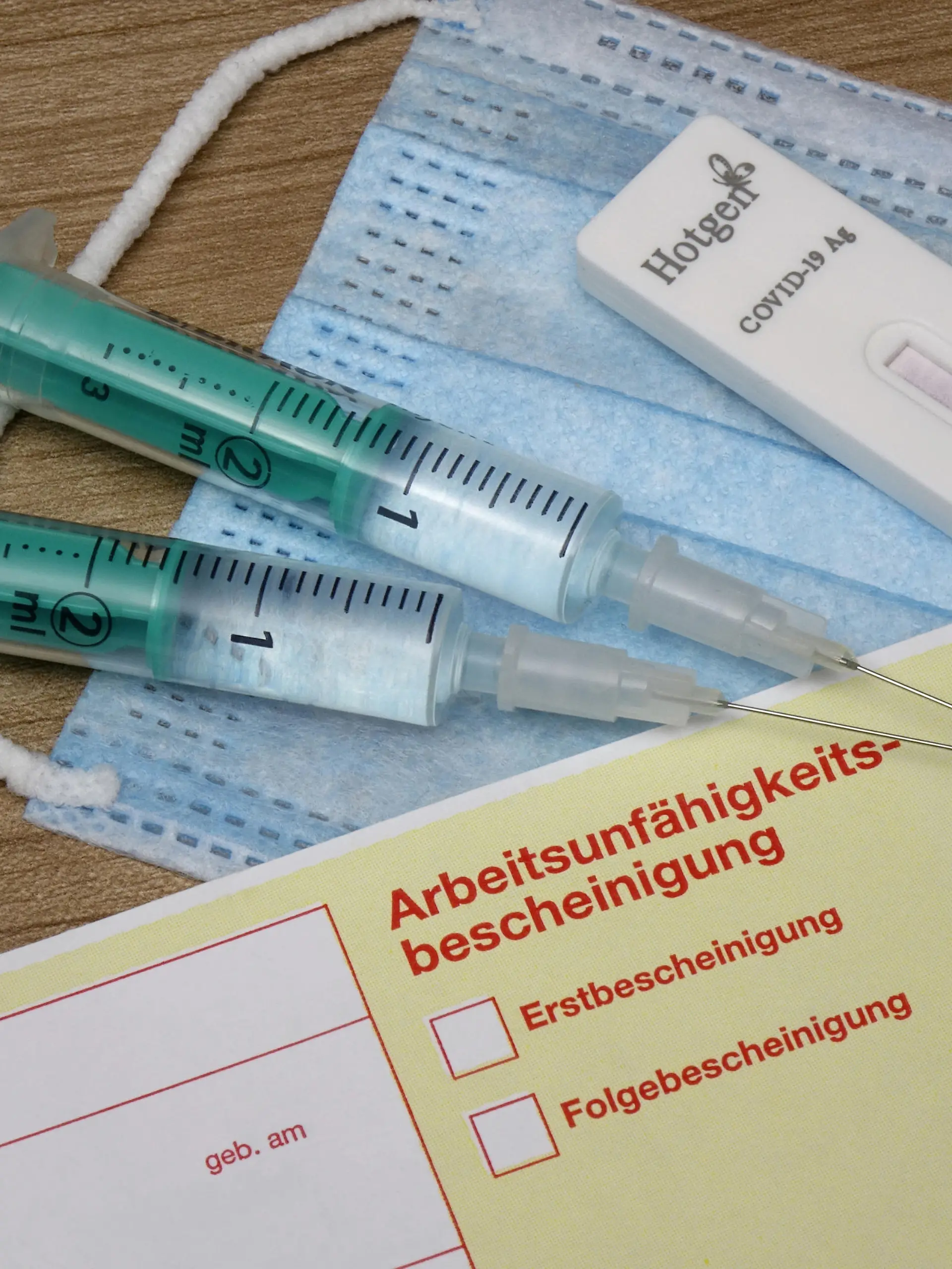 24.09.2021, Borkwalde, Brandenburg, Neben einem Krankenschein liegen Mundschutzmaske, Test Kit und zwei Spritzen.