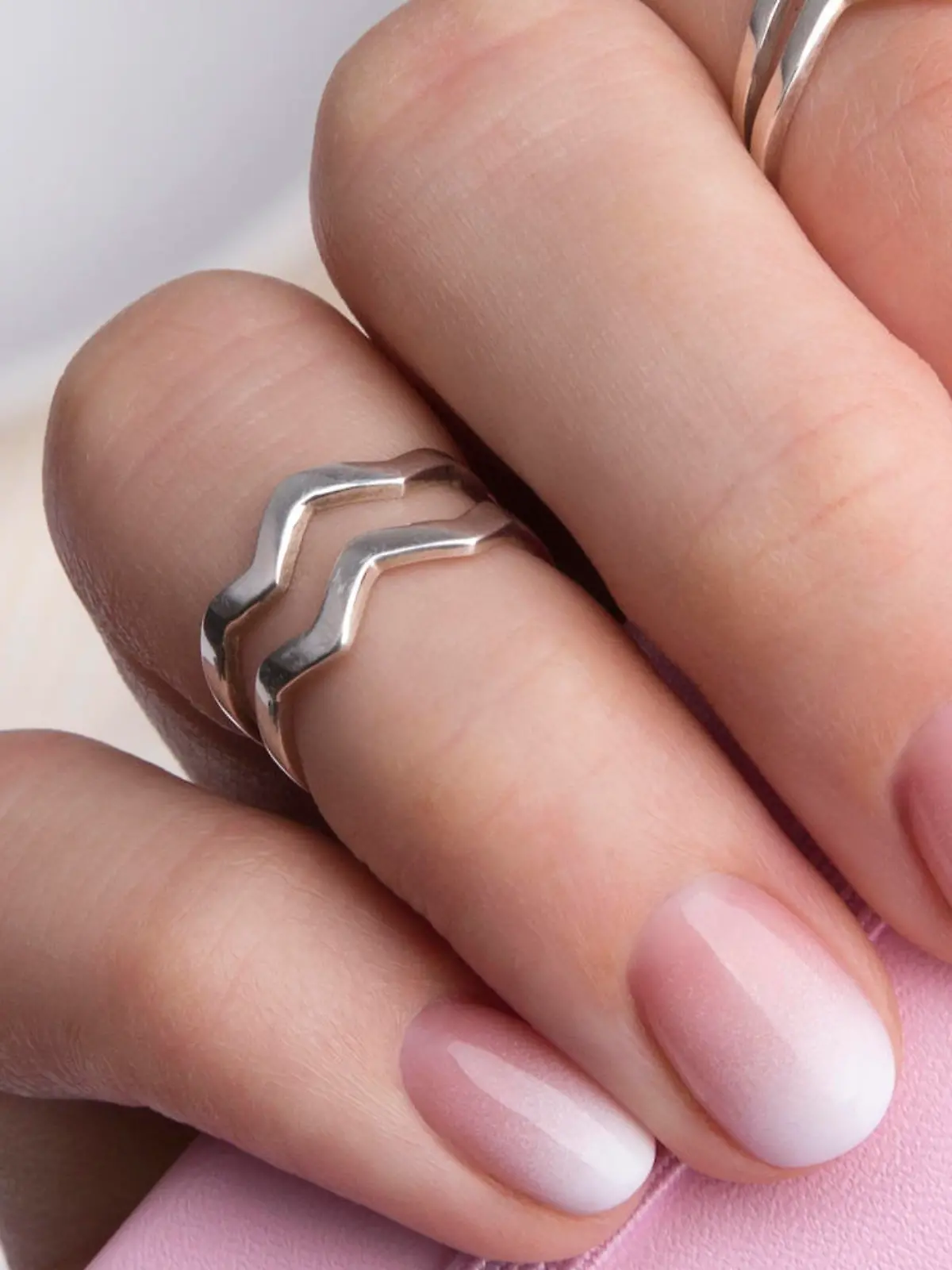 Beautiful manicured hand holding notepad at the office table. Ombre gradient nail design.