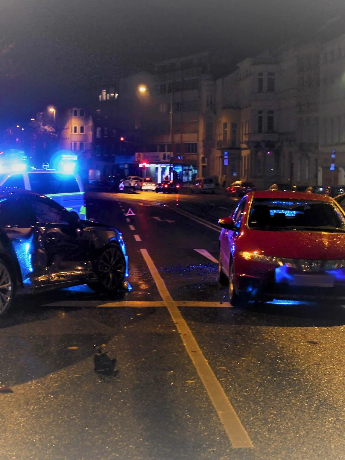 HANDOUT - 13.11.2021, Nordrhein-Westfalen, Aachen: Zwei Fahrzeuge stehen an einer Kreuzung am Kaiserplatz. Bei einem mutmaßlichen Rennen hat ein Autofahrer in Aachen einen Zusammenstoß verursacht, bei dem vier Menschen verletzt wurden. Der 18-Jährige hatte am späten Samstagabend offenbar bei hoher Geschwindigkeit die Kontrolle über seinen Wagen verloren, wie die Polizei am Sonntag mitteilte. Foto: ---/Polizei Aachen/dpa - ACHTUNG: Kfz-Kennzeichen wurde aus rechtlichen Gründen gepixelt +++ dpa-Bildfunk +++