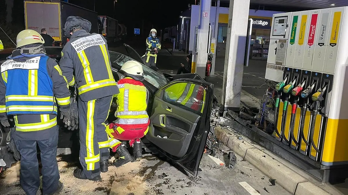 HANDOUT - 14.11.2021, Nordrhein-Westfalen, Bochum: Einsatzkräfte arbeiten an einem Auto, das an einer Tankstelle vor einer stark beschädigten Zapfsäule steht. Auf einem Tankstellengelände an der A40 bei Bochum ist am frühen Sonntagmorgen ein Auto gegen eine Tanksäule geprallt. Die vier Insassen des Wagens seien schwer verletzt ins Krankenhaus gebracht worden, teilte die Feuerwehr mit. (zu dpa "Auto fährt in Zapfsäule - vier Schwerverletzte") Foto: Feuerwehr Bochum/dpa - ACHTUNG: Nur zur redaktionellen Verwendung im Zusammenhang mit der aktuellen Berichterstattung und nur mit vollständiger Nennung des vorstehenden Credits +++ dpa-Bildfunk +++