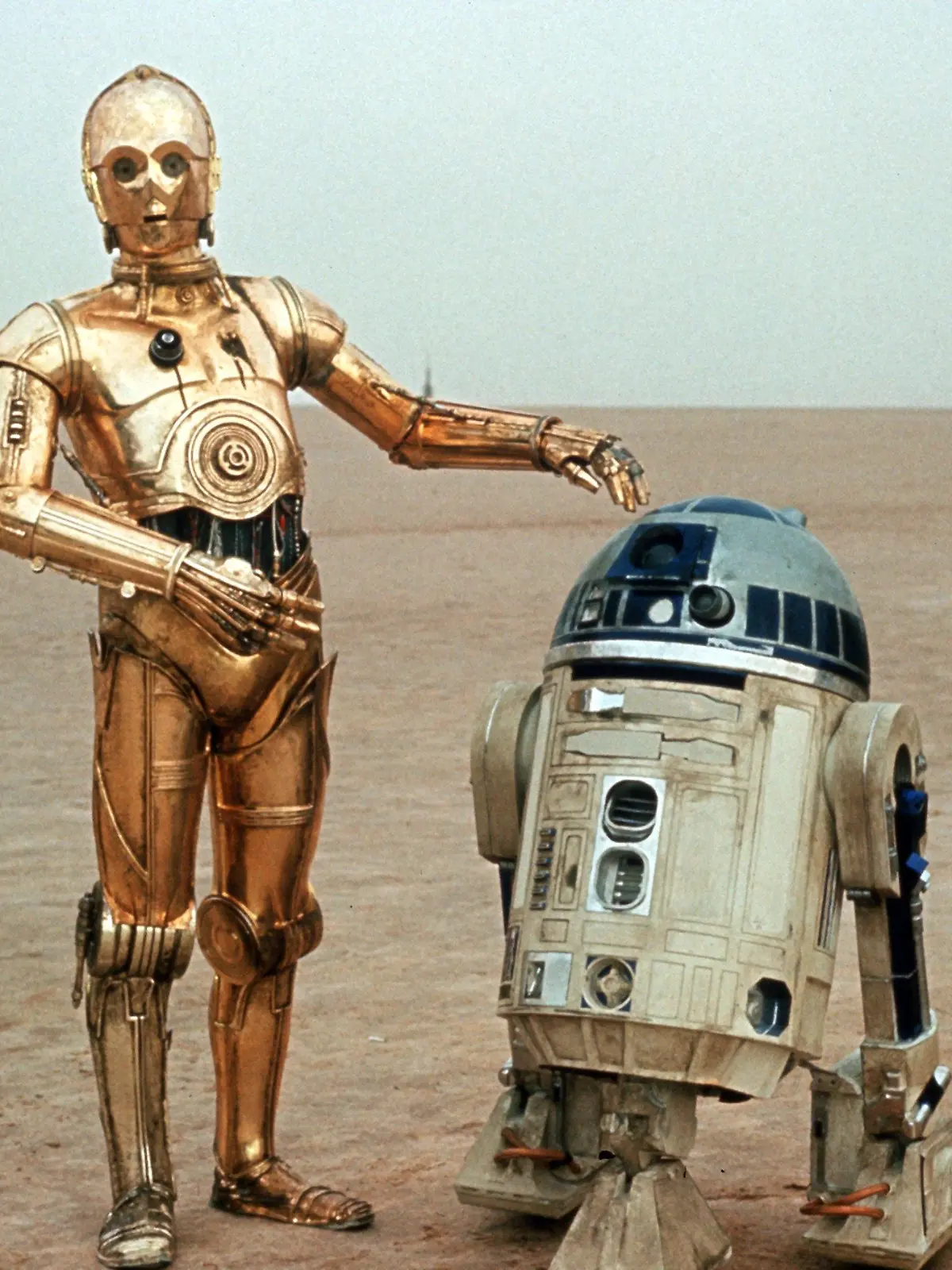 Die beiden Roboter C-3PO (l, Anthony Daniels) und R2-D2 (Kenny Baker) im zweiten Teil der "Star Wars"-Saga, "Das Imperium schlägt zurück" (Szenenfoto). 20 Jahre nach ihrem ersten Siegeszug kehrt die Weltraum-Trilogie von George Lucas nach technischer Generalüberholung - die damals schon innovativen Filme erhielten ein hypermodernes Sounddesign und zusätzliche Spezialeffekte - ins Kino zurück. Die Wiederaufführung des ersten Teils verlief überaus erfolgreich: "Krieg der Sterne" eroberte auf Anhieb die Spitze der deutschen Kinocharts. Starttermin von Teil zwei, "Das Imperium schlägt zurück", ist der 10.4.1997, "Die Rückkehr der Jedi-Ritter" ist ab dem 24.4. zu sehen.