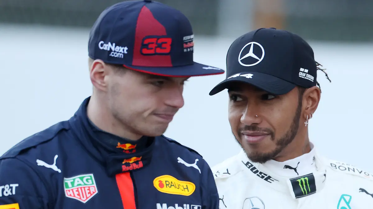 ARCHIV - 19.02.2020, Spanien, Barcelona: Formel 1, Testfahrt: Lewis Hamilton (r) aus Großbritannien vom Team Mercedes AMG Petronas und Max Verstappen aus den Niederlanden vom Red Bull (damals noch Red Bull/Aston Martin) sprechen zusammen auf dem Circuit de Catalunya. Im WM-Duell zwischen Max Verstappen und Lewis Hamilton legt die Formel 1 einen letzten Sprint in Brasilien ein. (Zu dpa "Verstappen und Hamilton im Formel-1-Sprintduell") Foto: David Davies/PA Wire/dpa +++ dpa-Bildfunk +++