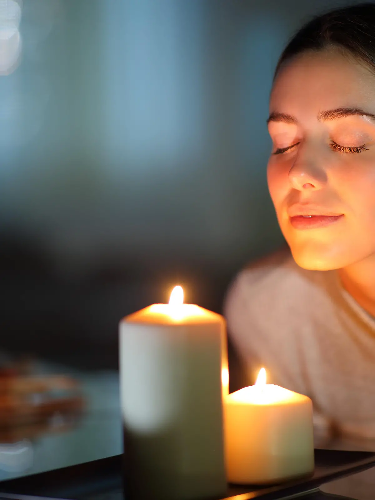 Woman smelling a lighted candle in the night