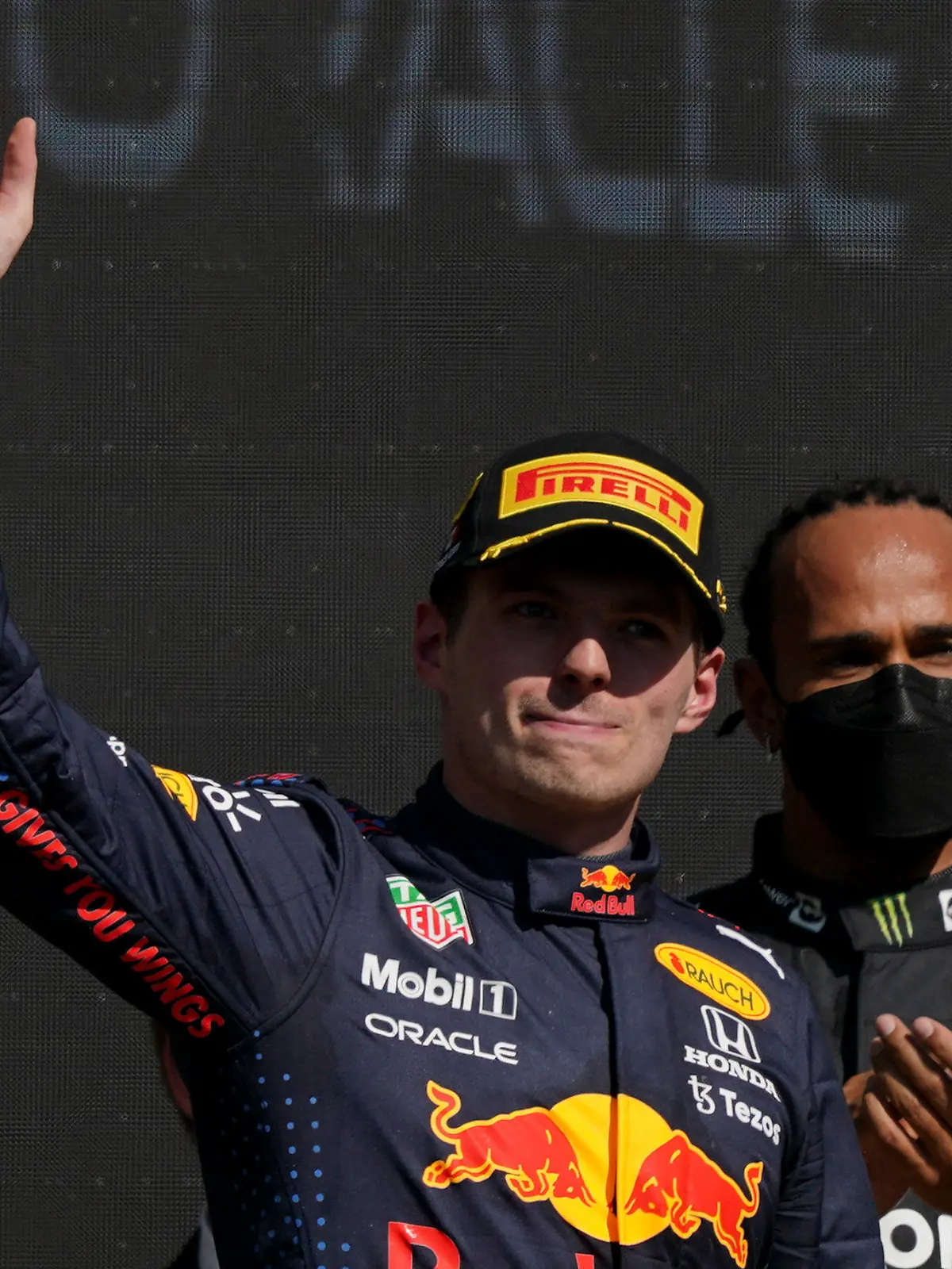 Red Bull's Max Verstappen, left, waves as he celebrates winning first place as second placed Mercedes'Lewis Hamilton looks on at the end the Formula One Mexico Grand Prix auto race at the Hermanos Rodriguez racetrack in Mexico City, Sunday, Nov. 7, 2021. (AP Photo/Fernando Llano)