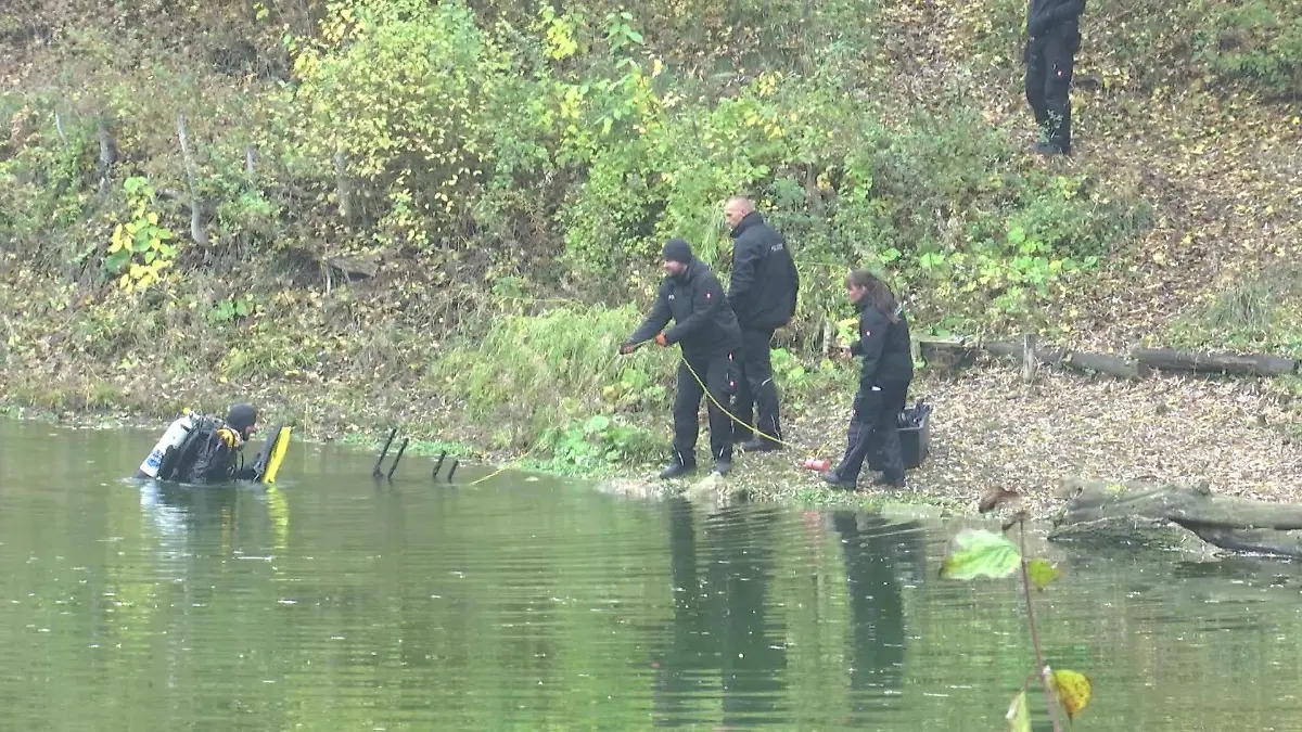 Polizei-Taucher suchen Smartphone in einem See.
