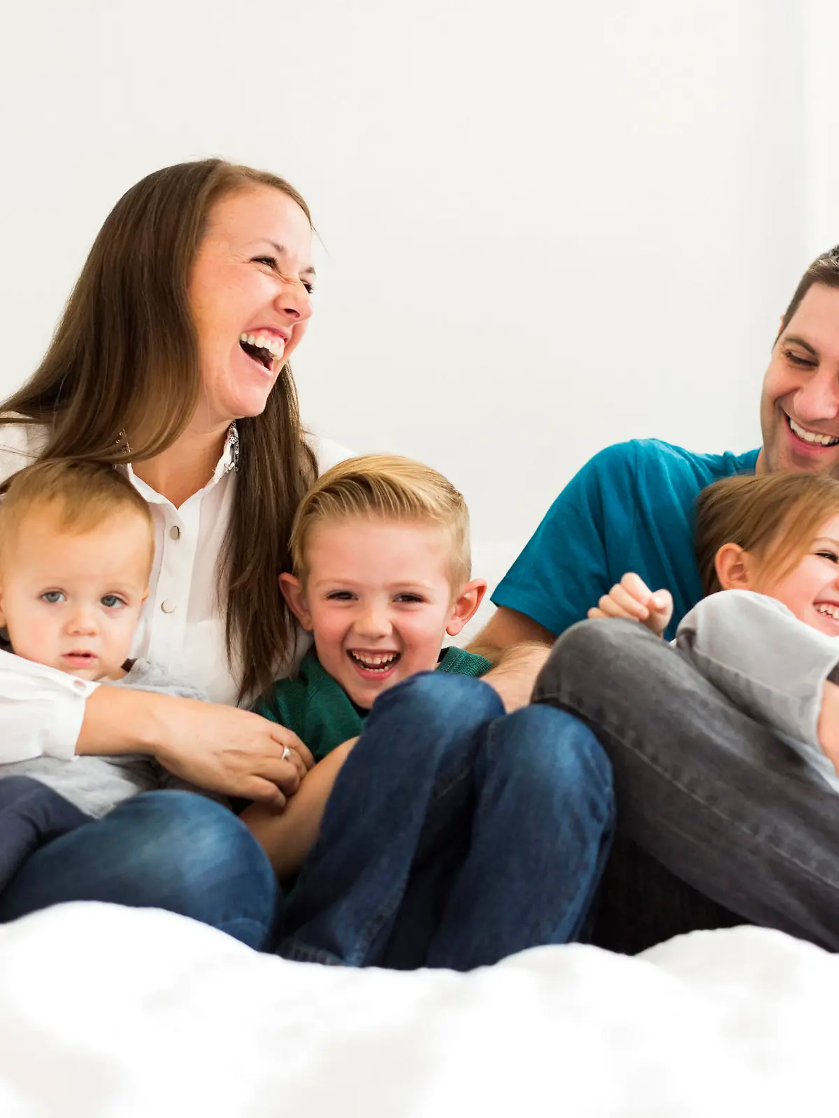 Family with three children (2-3, 4-5) laughing on bed Keine Weitergabe an Drittverwerter.