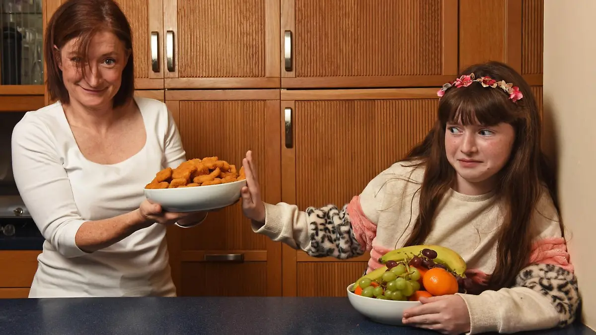 WILLIAM LAILEY / MERCURY PRESS (PICTURED:  Julia, 49 and her daughter Jessica, 11, )  -  A schoolgirl who lived off chicken nuggets for a DECADE has finally overcome her food phobia. Jessica, 11, spent her life so far eating just chicken nuggets after refusing to try new foods at 18 months old. Her mum, Julia, 49, a graphic designer, has no idea what triggered the anxiety and panic surrounding food - but after seeking professional help Jessica was diagnosed with avoidant restrictive food intake disorder (ARFID) just last month. Now after just a few weeks of work with her therapist who used relaxation MP4s to play before meals and rewards for overcoming her phobia, Jessica can finally enjoy a full roast dinner, as well as lots of fruit and vegetables. -   SEE MERCURY COPY