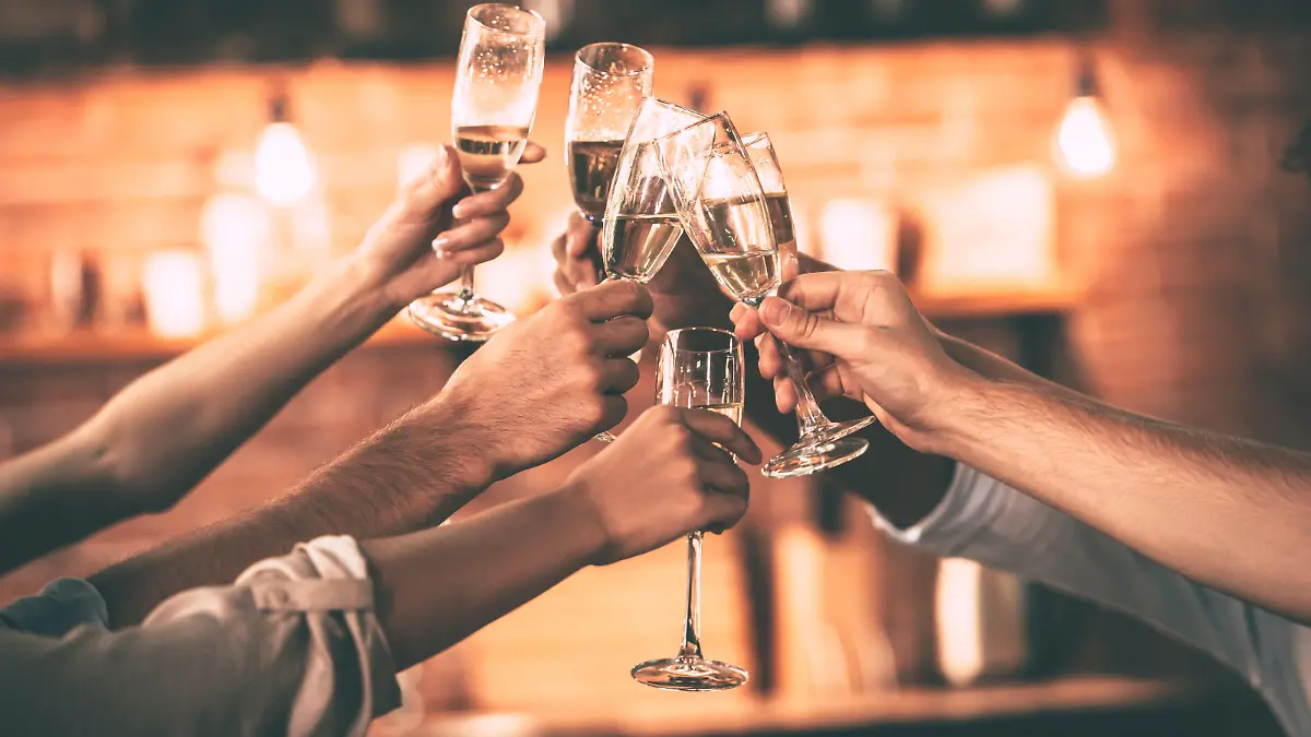 Group of people cheering with champagne flutes with home interior in the background