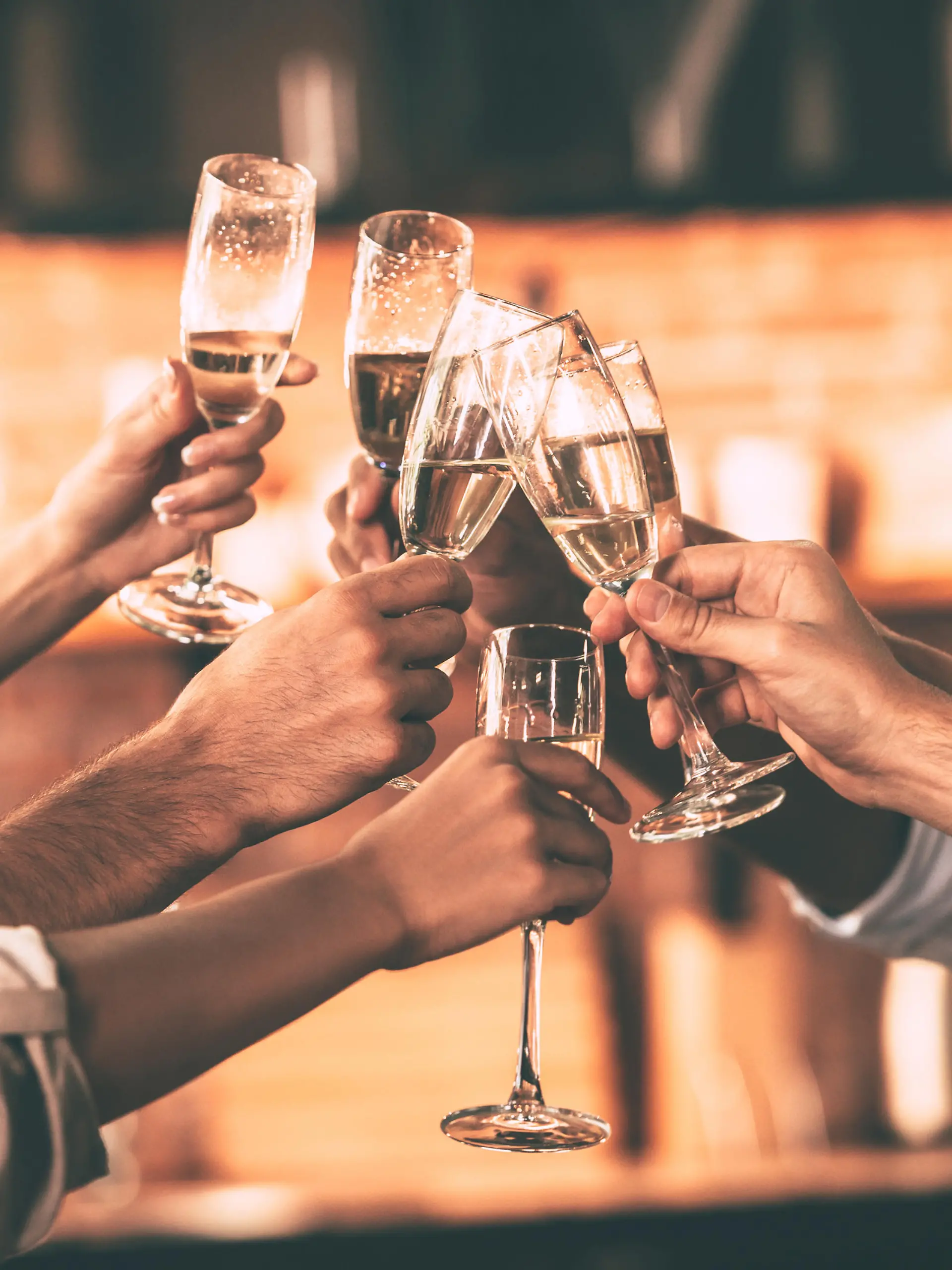 Group of people cheering with champagne flutes with home interior in the background
