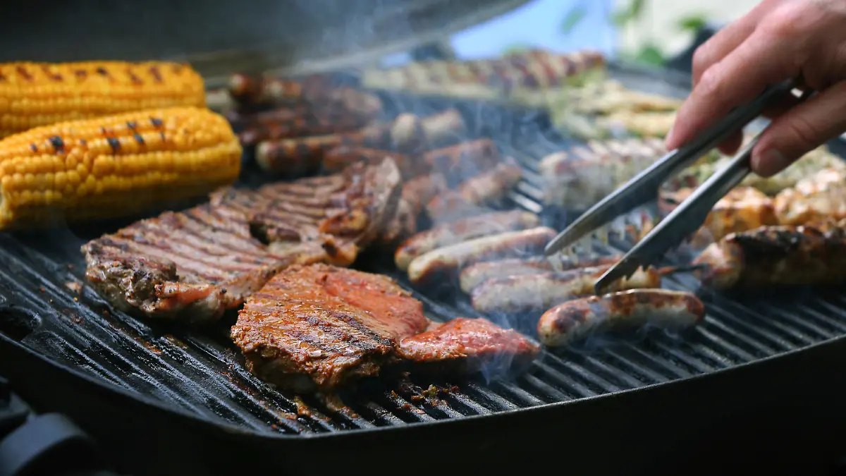 ARCHIV - 26.05.2018, Bayern, München: Maiskolben, Fleischspieße, Bratwürste und Steaks liegen auf dem Rost eines Gasgrills.   (zu dpa «Schweinenackensteak beliebtes Grillfleisch - Spezialitäten im Kommen» vom 04.08.2018) Foto: Karl-Josef Hildenbrand/dpa +++ dpa-Bildfunk +++
