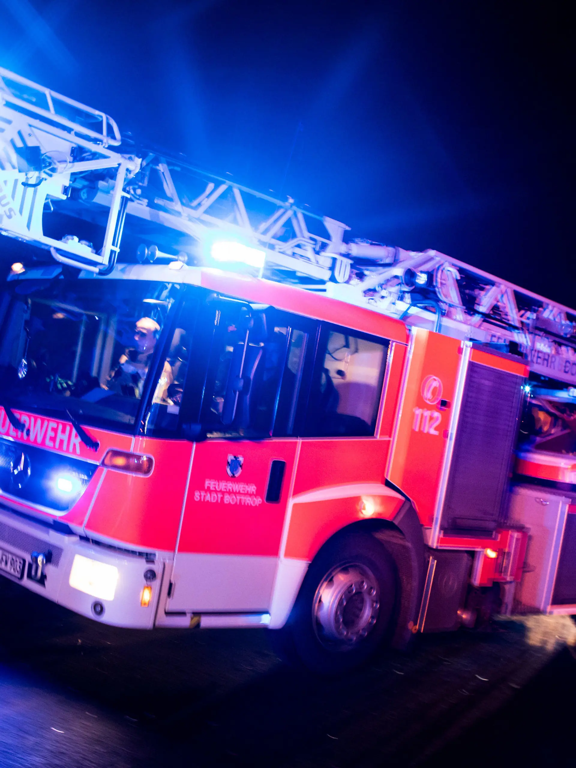 ARCHIV - 21.01.2018, Nordrhein-Westfalen, Bottrop: ILLUSTRATION - Ein Drehleiterwagen der Feuerwehr fährt mit Blaulicht an einer Unfallstelle vorbei. Der Verband der Feuerwehren in NRW trifft sich zu Sondersitzung in Wuppertal. Foto: Marcel Kusch/dpa +++ dpa-Bildfunk +++