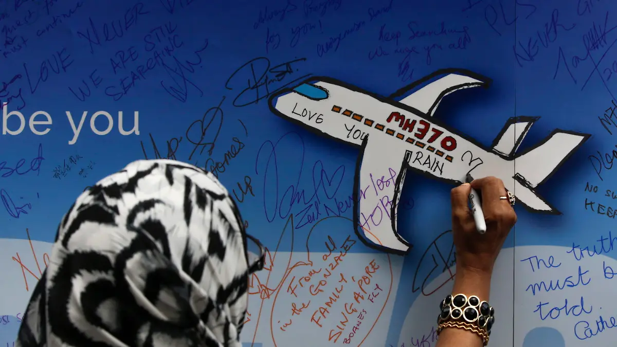 ARCHIV - 06.03.2016, Malaysia, Kuala Lumpur: Eine Frau schreibt während einer Gedenkveranstaltung zum Flug MH370 eine Nachricht auf ein Banner. Fünf Jahre ist es her, dass Flug MH370 kurz nach dem Start verschwand - einfach so. Seither wurden nur ein paar Wrackteile gefunden. Ansonsten: keine Spur. Die Verzweiflung der Angehörigen ist groß, immer noch. (zu dpa "Das große Rätsel MH370: Angehörige auch nach fünf Jahren verzweifelt") Foto: Fazry Ismail/EPA/dpa +++ dpa-Bildfunk +++