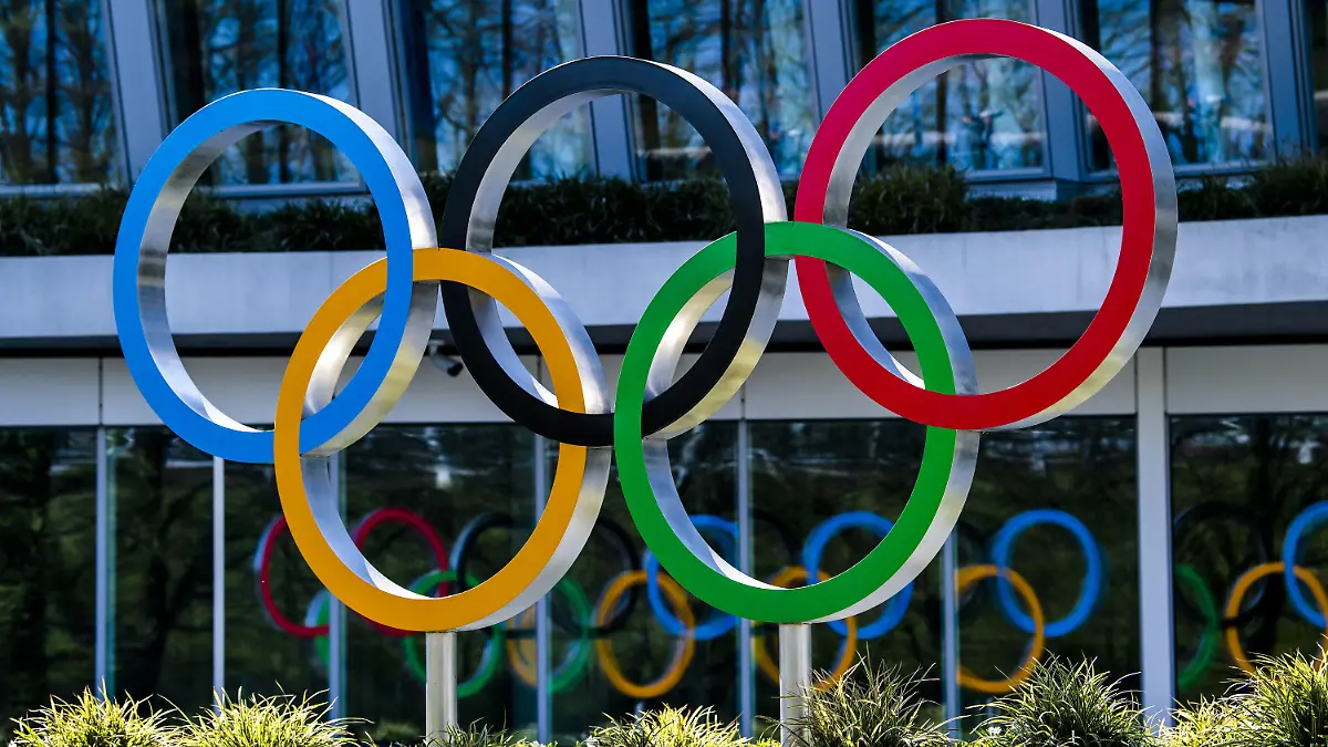 24.03.2020, Schweiz, Lausanne: Die Olympischen Ringe werden am Eingang des IOC, dem Sitz des Internationalen Olympischen Komitees, in Lausanne ausgestellt. Die Olympischen Spiele in Tokio sollen verschoben werden, spätestens aber im Sommer 2021 stattfinden. Das haben das Internationale Olympische Komitee und die Olympia-Organisatoren in Japan gemeinsam am Dienstag beschlossen, wie das IOC mitteilte. Foto: Jean-Christophe Bott/KEYSTONE/dpa +++ dpa-Bildfunk +++