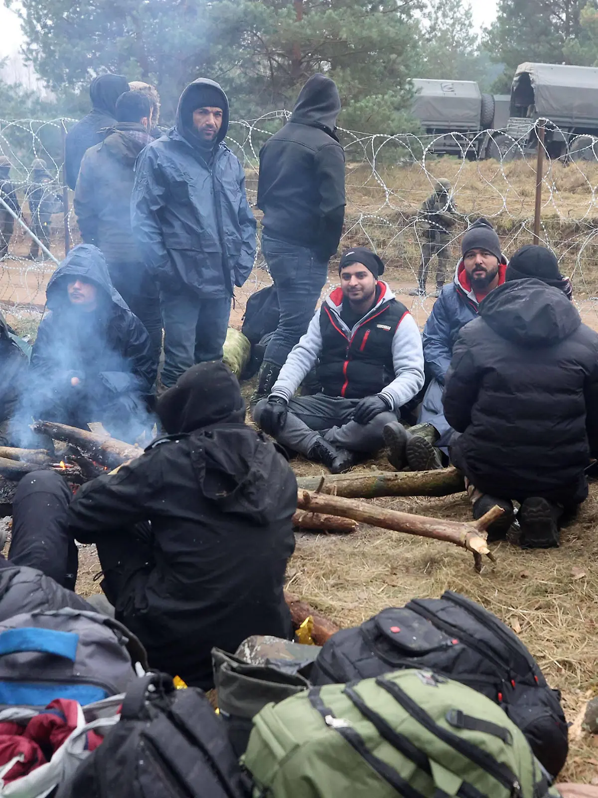  GRODNO REGION, BELARUS - NOVEMBER 10, 2021: Migrants sit by a bonfire at a tent camp on the Belarusian-Polish border. According to the Polish Border Guard, several thousand migrants have been approaching the Polish border since November 8, 2021. Since the start of 2021, over 30 thousand migrants have attempted to cross the Belarusian-Polish border. Poland has declared a state of emergency in the regions bordering Belarus. Leonid Shcheglov/BelTA/TASS PUBLICATIONxINxGERxAUTxONLY TS1175D7
