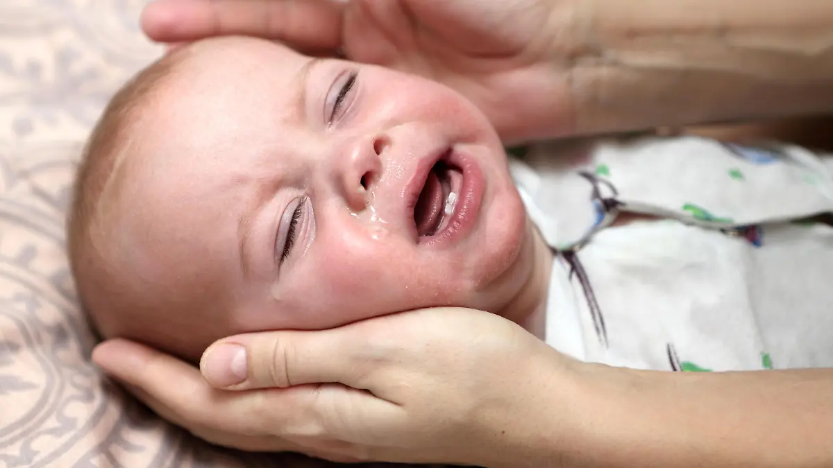 Crying child with a runny nose at home