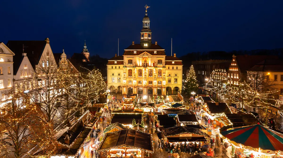 ARCHIV - 11.12.2019, Niedersachsen, Lüneburg: Besucher gehen in Lüneburg über den Weihnachtsmarkt vor dem Rathaus der Stadt. Viele niedersächsische Städte wollen in diesem Jahr in ihren Innenstädten wieder Weihnachtsmärkte veranstalten, doch Besucher müssen überall Corona-Auflagen beachten. Foto: Philipp Schulze/dpa +++ dpa-Bildfunk +++