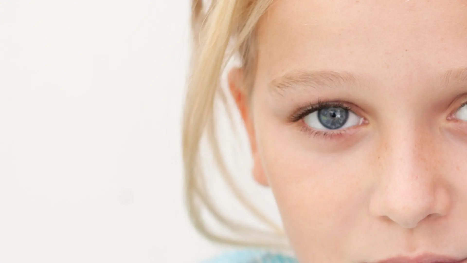 Close up of child with fever thermometer, wrapped in blanket