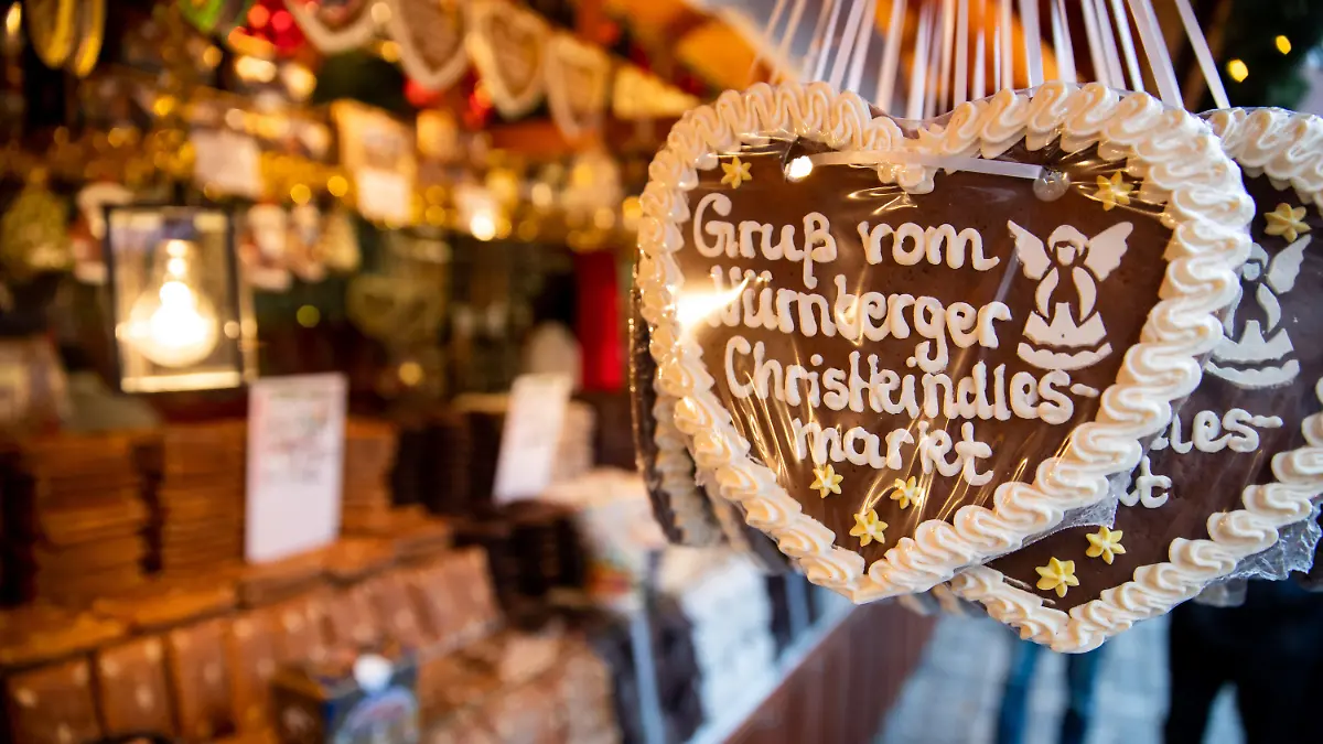 ARCHIV - 30.11.2018, Bayern, Nürnberg: Lebkuchenherzen mit der Aufschrift «Gruß vom Nürnberger Christkindlesmarkt» hängen an einem Stand auf dem Nürnberger Christkindlesmarkt zum Verkauf aus. (zu dpa: «Umfrage: Bundesbürger schwärmen für Atmosphäre der Weihnachtsmärkte») Foto: Daniel Karmann/dpa +++ dpa-Bildfunk +++