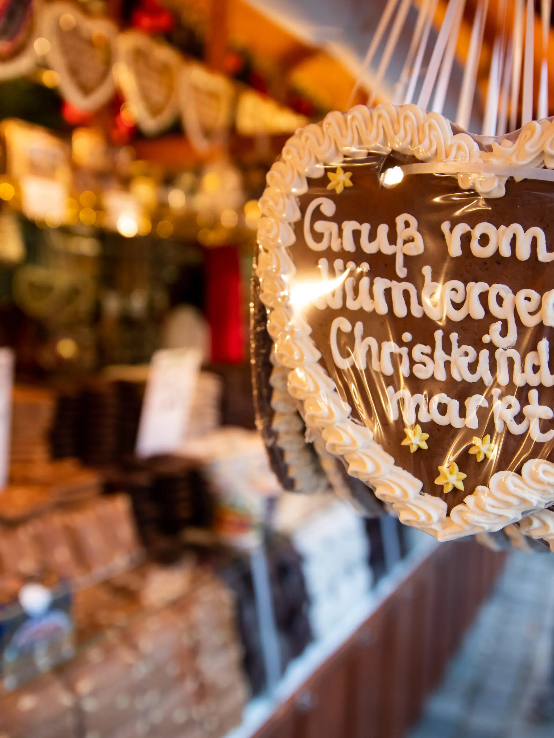 ARCHIV - 30.11.2018, Bayern, Nürnberg: Lebkuchenherzen mit der Aufschrift «Gruß vom Nürnberger Christkindlesmarkt» hängen an einem Stand auf dem Nürnberger Christkindlesmarkt zum Verkauf aus. (zu dpa: «Umfrage: Bundesbürger schwärmen für Atmosphäre der Weihnachtsmärkte») Foto: Daniel Karmann/dpa +++ dpa-Bildfunk +++