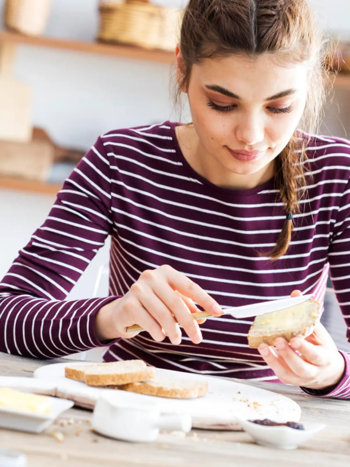 Young woman eating bread with butter