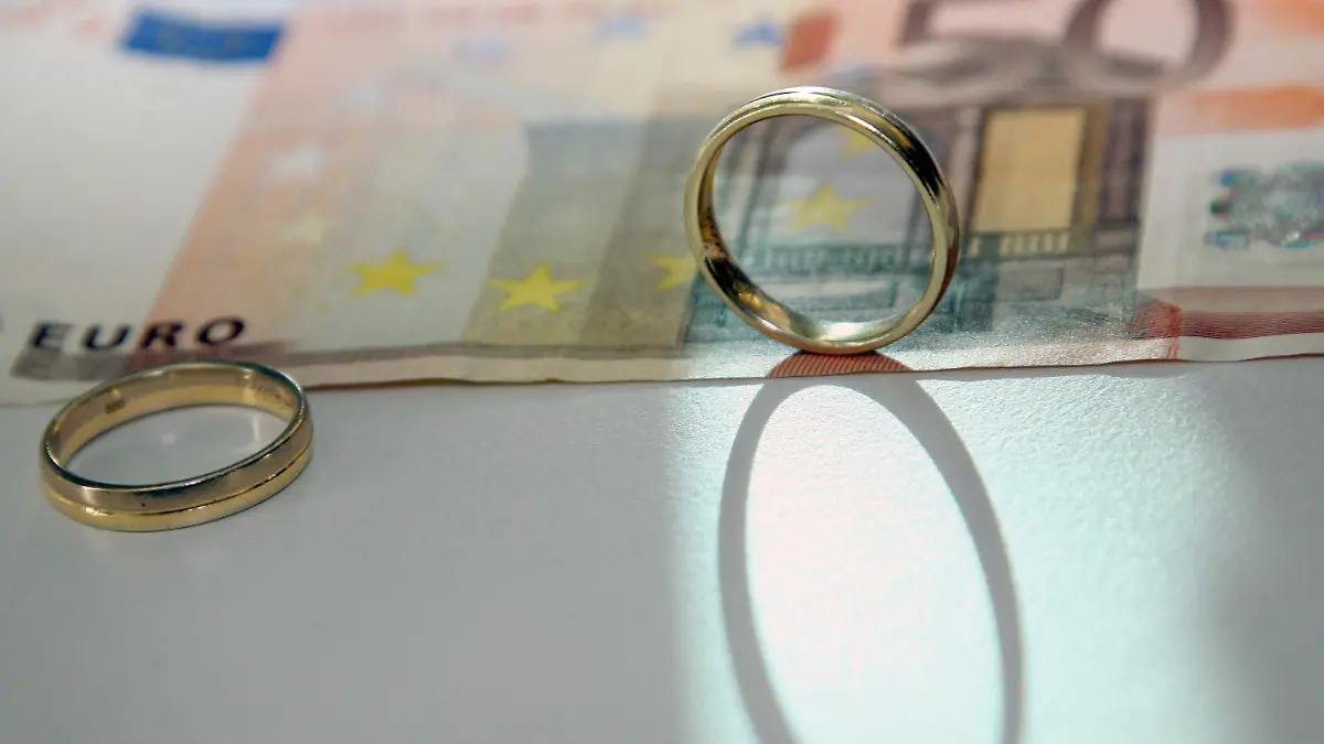 ILLUSTRATION - Zwei Eheringe stehen auf Geldscheinen, aufgenommen am Freitag (11.02.2011) in Berlin. Das Bundesverfassungsgericht stärkt die Unterhaltsansprüche geschiedener Ehepartner. Der Maßstab für den Unterhalt müsse unabhängig davon bestimmt werden, ob der unterhaltspflichtige Partner erneut geheiratet hat. Foto: Stephanie Pilick dpa/lbn  +++(c) dpa - Bildfunk+++