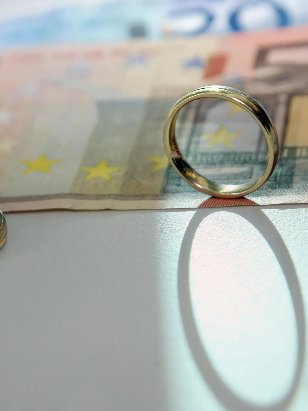 ILLUSTRATION - Zwei Eheringe stehen auf Geldscheinen, aufgenommen am Freitag (11.02.2011) in Berlin. Das Bundesverfassungsgericht stärkt die Unterhaltsansprüche geschiedener Ehepartner. Der Maßstab für den Unterhalt müsse unabhängig davon bestimmt werden, ob der unterhaltspflichtige Partner erneut geheiratet hat. Foto: Stephanie Pilick dpa/lbn  +++(c) dpa - Bildfunk+++