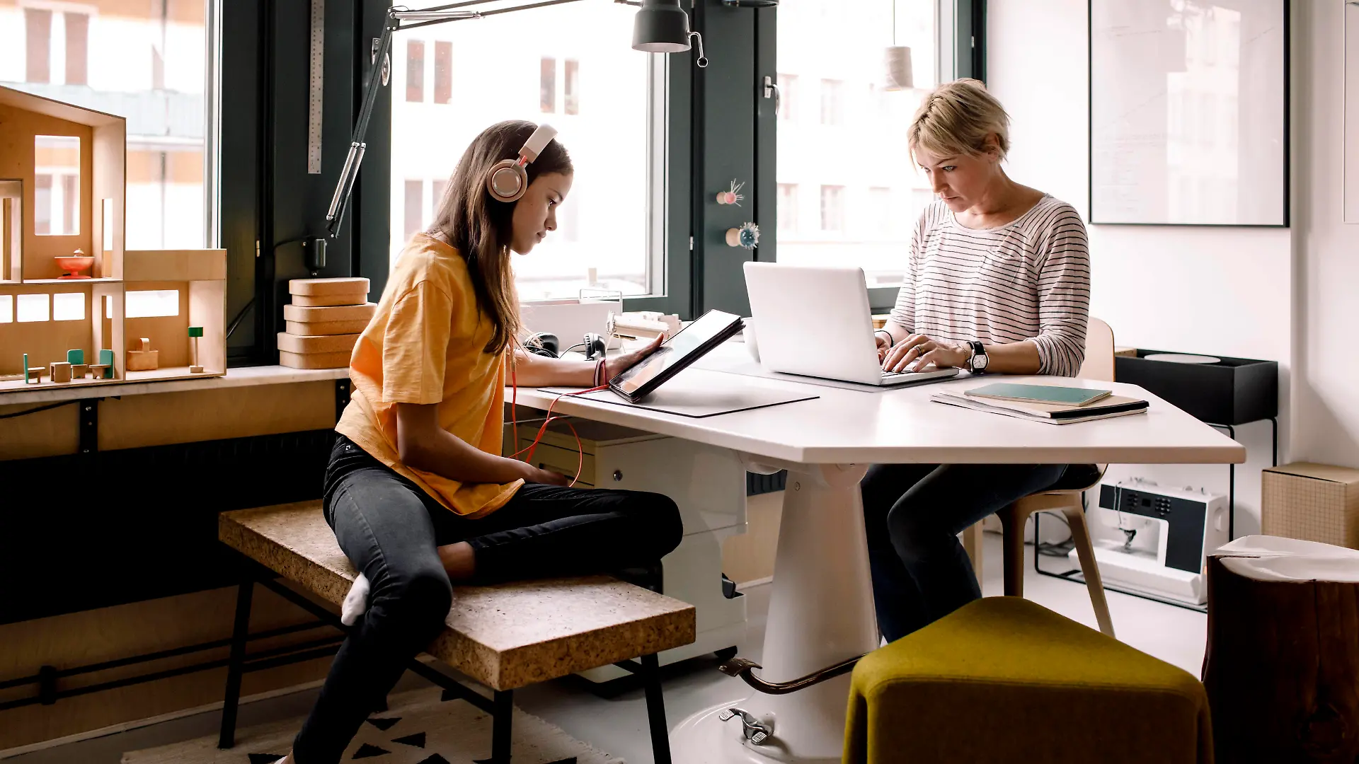 Businesswoman working while daughter learning through digital tablet at home Sweden, Stockholm, model released, property released Copyright: xMaskotx , MA86571