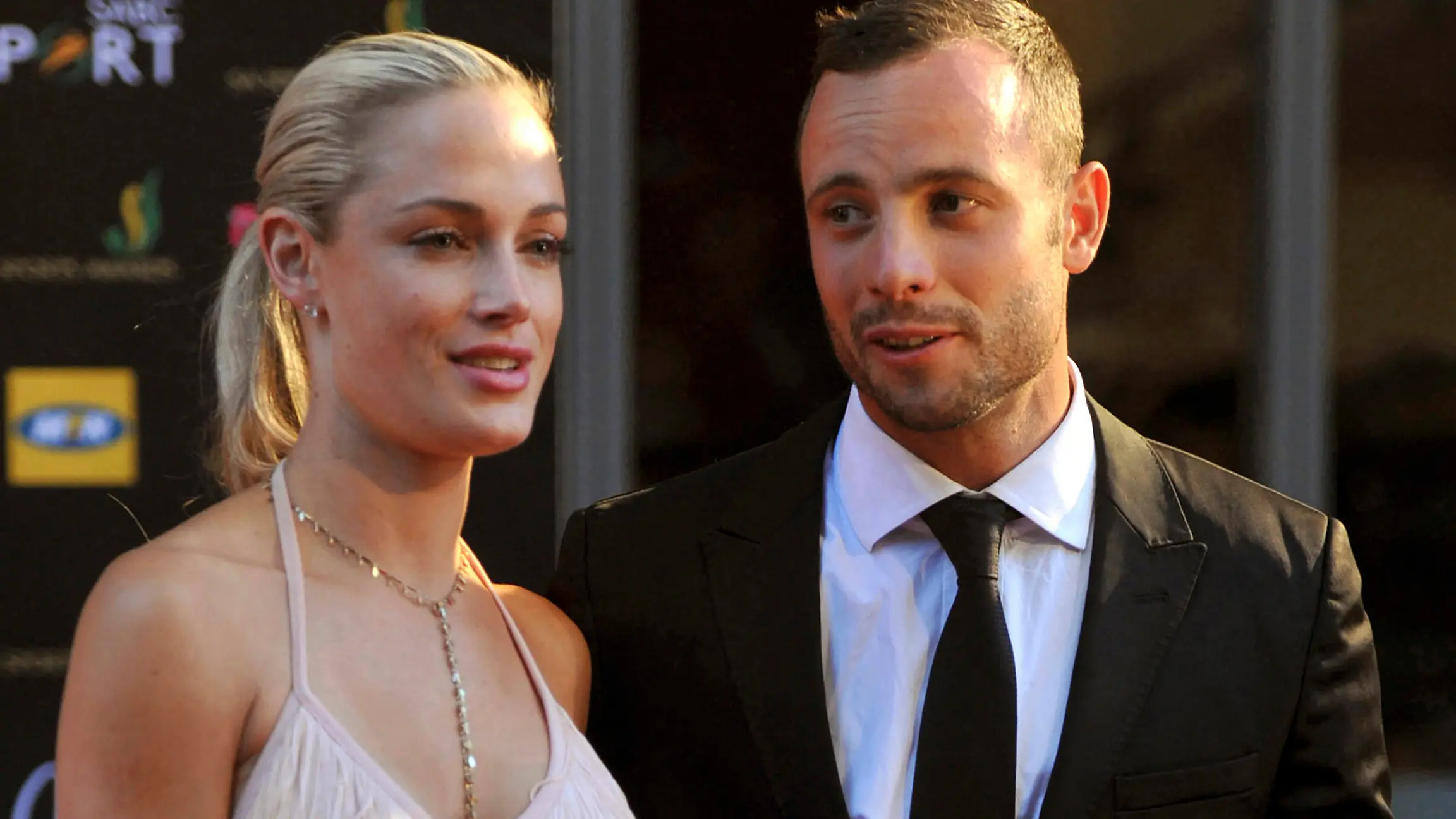 FILE - South African Olympic athlete Oscar Pistorius, right, and his girlfriend, the late Reeva Steenkamp, left, arrive at an awards ceremony in Johannesburg, South Africa. Nov. 4, 2012. Eight years after he shot dead his girlfriend, Pistorius is up for parole, but first he must meet with her parents as part of the parole procedure. A parole hearing for Pistorius was scheduled for last month and then canceled, partly because a meeting between Pistorius and Steenkamp's parents, Barry and June, had not been arranged, lawyers for both parties told The Associated Press on Monday, Nov. 8, 2021.  (Lucky Nxumalo/Citypress via AP, File)