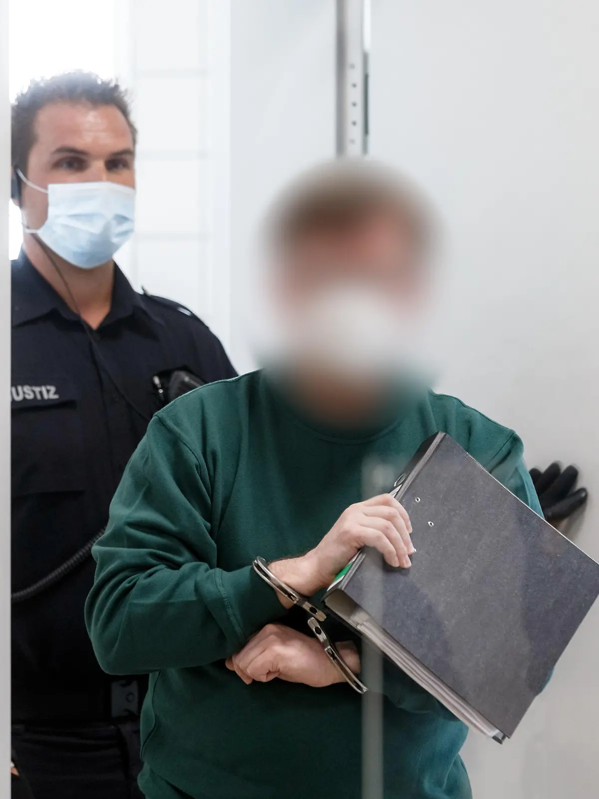 ARCHIV - 08.07.2021, Schleswig-Holstein, Lübeck: Der 57 Jahre alte Angeklagte (r) betritt einen Gerichtssaal im Landgericht. Er soll am 30. Dezember 2020 einen 38-Jährigen erschossen haben, den er für einen Einbrecher hielt. Im Prozess wird nun das Urteil erwartet Foto: Markus Scholz/dpa - ACHTUNG: Person(en) wurde(n) aus rechtlichen Gründen gepixelt +++ dpa-Bildfunk +++