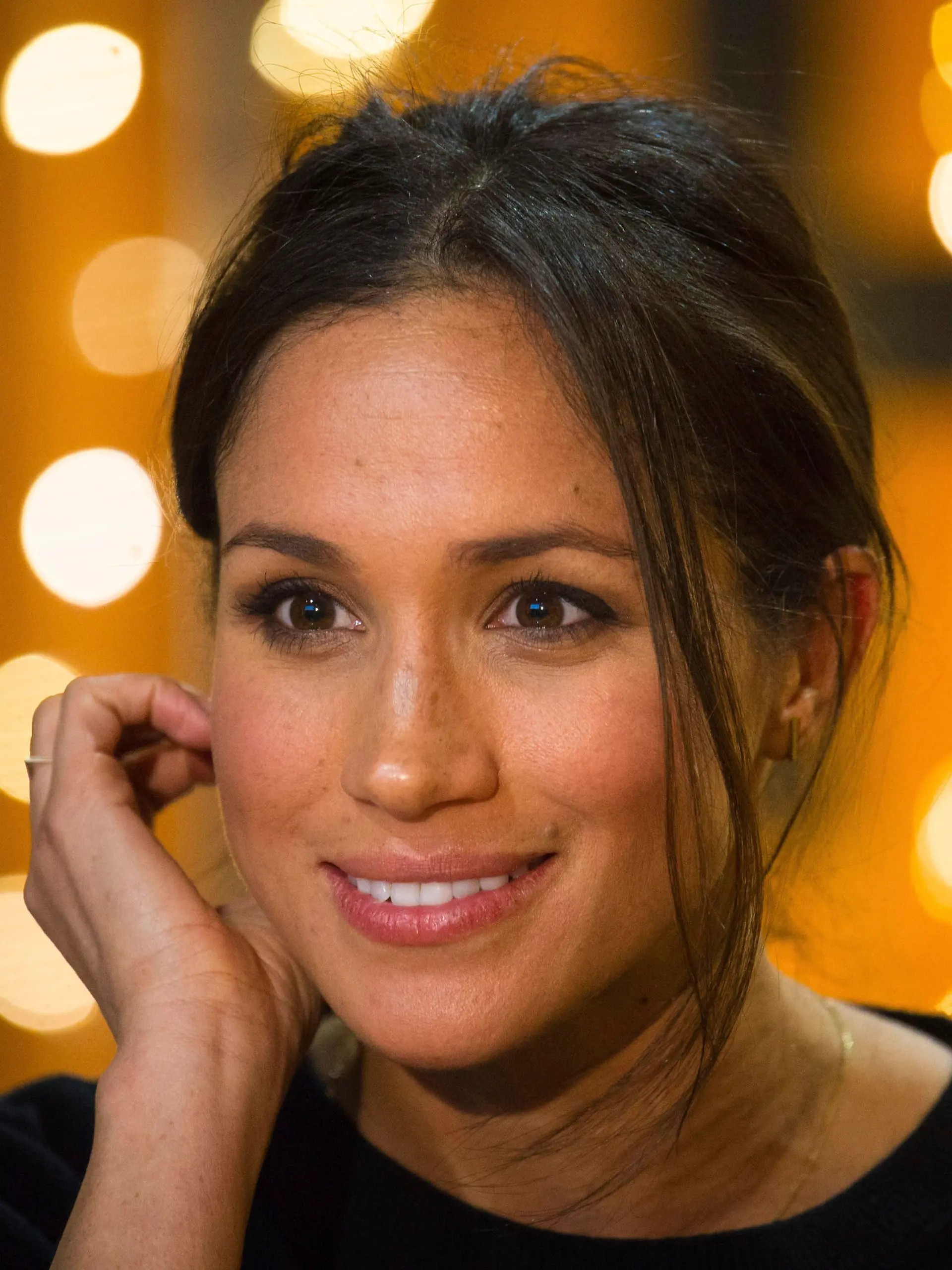 Meghan Markle smiles during a visit with Britain's Prince Harry to the Reprezent 107.3 FM radio station in Brixton, south London, Tuesday, Jan. 9, 2018. The royal couple visited Tuesday to see the station's work supporting young people through creative training in radio and broadcasting, and to learn more about their model of using music, radio and media for social impact. (AP Photo/ Dominic Lipinski, Pool)