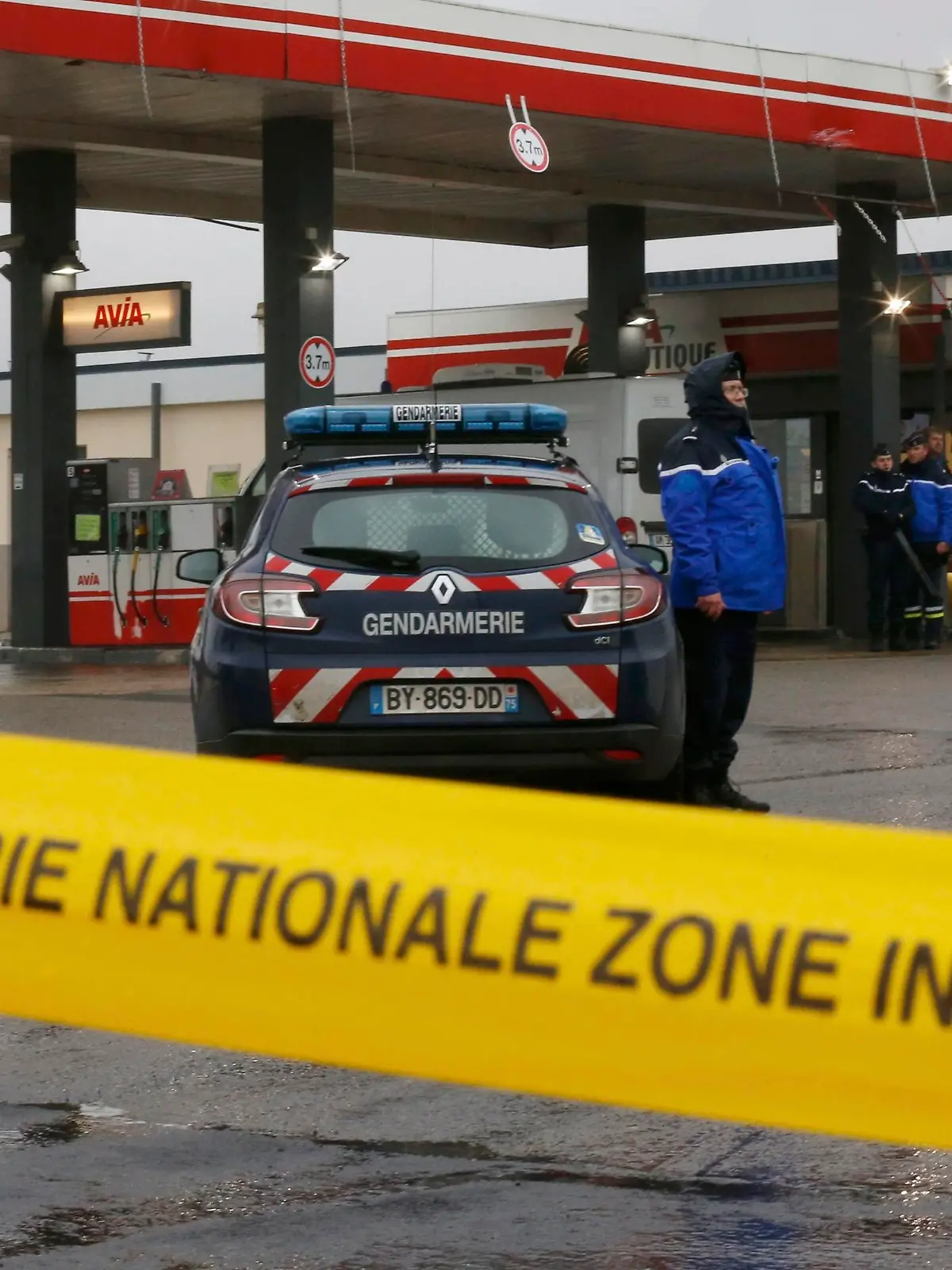 A Gendarmerie cordon is seen at a gas station in Villers-Cotterets, north-east of Paris, January 8, 2015, where armed suspects from the attack on French satirical weekly newspaper Charlie Hebdo were spotted in a car. French police extended a manhunt on Thursday for two brothers suspected of killing 12 people at the weekly satirical newspaper Charlie Hebdo in Paris in a presumed Islamist militant strike that national leaders and allied states described as an assault on democracy. France began a day of mourning for the journalists and police officers shot dead on Wednesday morning by black-hooded gunmen using Kalashnikov assault rifles. French tricolour flags flew at half mast throughout the country.  REUTERS/Pascal Rossignol (FRANCE  - Tags: CRIME LAW MILITARY)  
