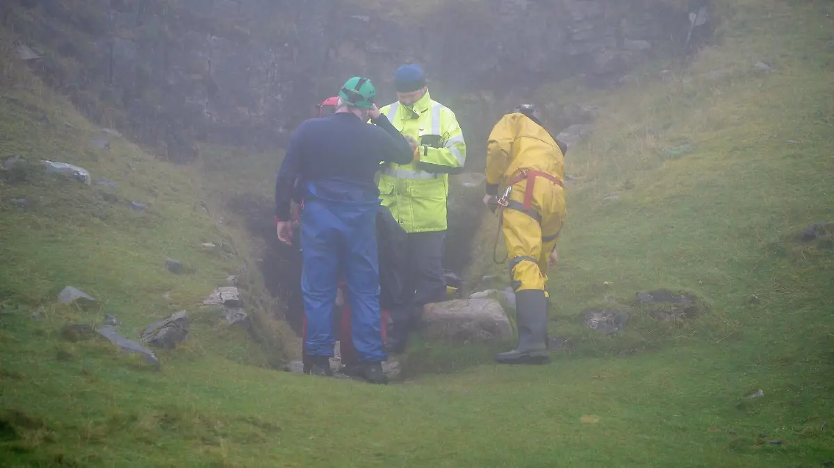 08.11.2021, Großbritannien, Penwyllt: Einsatzkräfte stehen am Höhlensystem Ogof Ffynnon Ddu, um einen Mann zu retten, der nach einem Sturz in einer Höhle gefangen ist. Mit einer großen Rettungsaktion haben Helfer am Montag (08.11.2021) versucht, einen verunglückten Mann aus einer Höhle in Wales zu retten. Wie der Sender BBC berichtete, soll sich der Unfall bereits am Samstag ereignet haben. Der Mann habe sich bei einem Sturz Verletzungen zugezogen und könne die Höhle nicht mehr aus eigener Kraft verlassen, hieß es im Bericht. Foto: Ben Birchall/PA Wire/dpa +++ dpa-Bildfunk +++