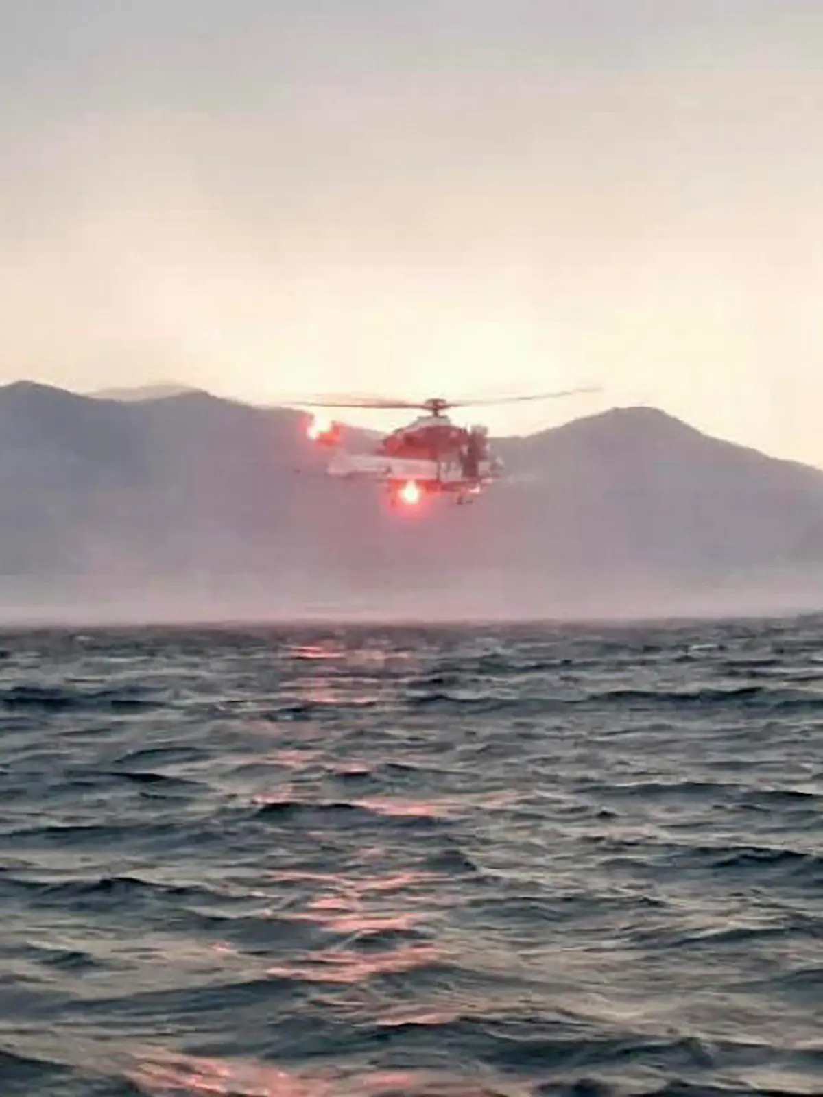 HANDOUT - 28.05.2023, Italien, Lago Maggiore: Dieses von der italienischen Feuerwehr veröffentlichten Bild zeigt einen Hubschrauber bei der Suche nach Vermissten, nachdem ein Touristen-Boot in einem Sturm auf dem italienischen Lago Maggiore gekentert ist. Bei einem Bootsunglück auf dem Lago Maggiore in Norditalien sind mehrere Menschen als vermisst gemeldet worden. Wie die italienischen Nachrichtenagenturen Ansa und Adnkronos berichteten, kam ein Mensch bei dem Vorfall am Sonntagabend ums Leben. Foto: Uncredited/Vigili del Fuoco/AP/dpa - ACHTUNG: Nur zur redaktionellen Verwendung bis zum 11.06.2023 im Zusammenhang mit der aktuellen Berichterstattung und nur mit vollständiger Nennung des vorstehenden Credits +++ dpa-Bildfunk +++