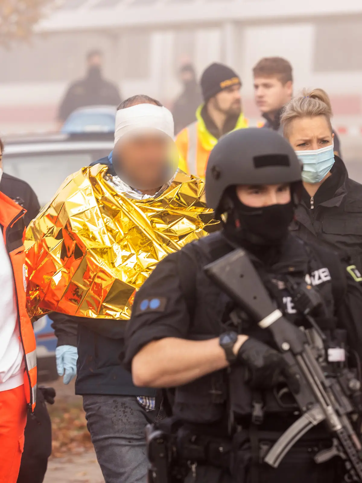 Eine festgenommene männliche Person wird am Bahnhof von Polizei und Rettungskräften weggeführt. In einem ICE zwischen Regensburg und Nürnberg hat es eine Messerattacke gegeben. Mehrere Menschen wurden verletzt, wie die Polizei mitteilte. Laut Polizeipräsidium Oberpfalz wurde eine männliche Person festgenommen.
