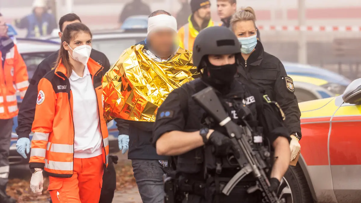 06.11.2021, Bayern, Seubersdorf: Eine festgenommene männliche Person wird am Bahnhof von Polizei und Rettungskräften weggeführt. In einem ICE zwischen Regensburg und Nürnberg hat es eine Messerattacke gegeben. Mehrere Menschen wurden verletzt, wie die Polizei mitteilte. Laut Polizeipräsidium Oberpfalz wurde eine männliche Person festgenommen. Foto: Fabian Schreiner/dpa - ACHTUNG: Mann aus persönlichkeitsrechtlichen Gründen gepixelt +++ dpa-Bildfunk +++