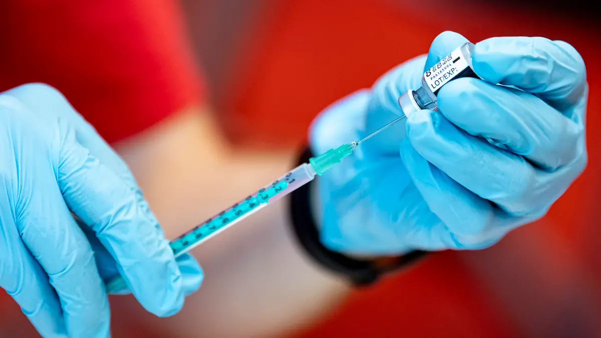 ARCHIV - 28.07.2021, Brandenburg, Potsdam: Eine Notfallsanitäter der DLRG zieht an der Universität Potsdam den Corona-Impfstoff von Biontech in eine Spritze. Auch wenn sich geimpfte Menschen mit dem Coronavirus infizieren, hilft die Spritze dennoch. Sie erkranken in jedem Fall seltener. (zu dpa «Erkrankung trotz Impfung: Was bedeuten Impfdurchbrüche?») Foto: Fabian Sommer/dpa +++ dpa-Bildfunk +++