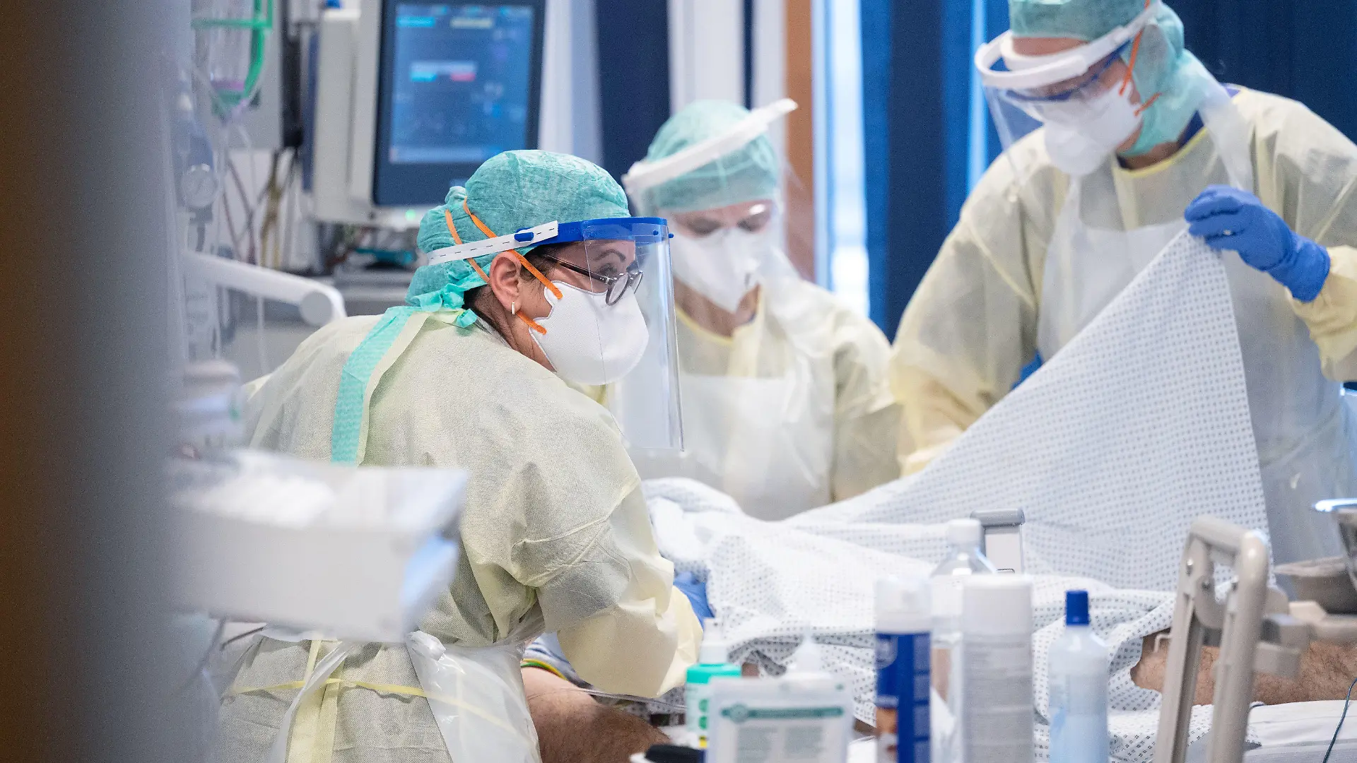 ARCHIV - 11.11.2020, Baden-Württemberg, Stuttgart: Ayse Yeter (l), Krankenschwester und Stationsleitung der Intensivstation für Covid-19 Patienten des Klinikum Stuttgart, versorgt in einem Patientenzimmer einen Covid-19-Patienten, der im künstlichen Koma liegt und beatmet wird. (zu dpa: «Kliniken bei Intensiv-Betten am Limit - Cluster sollen helfen») Foto: Marijan Murat/dpa - ACHTUNG: Nur zur redaktionellen Verwendung im Zusammenhang mit der Berichterstattung über die Intensivpflegerin Ayse Yeter und nur mit vollständiger Nennung des vorstehenden Credits +++ dpa-Bildfunk +++