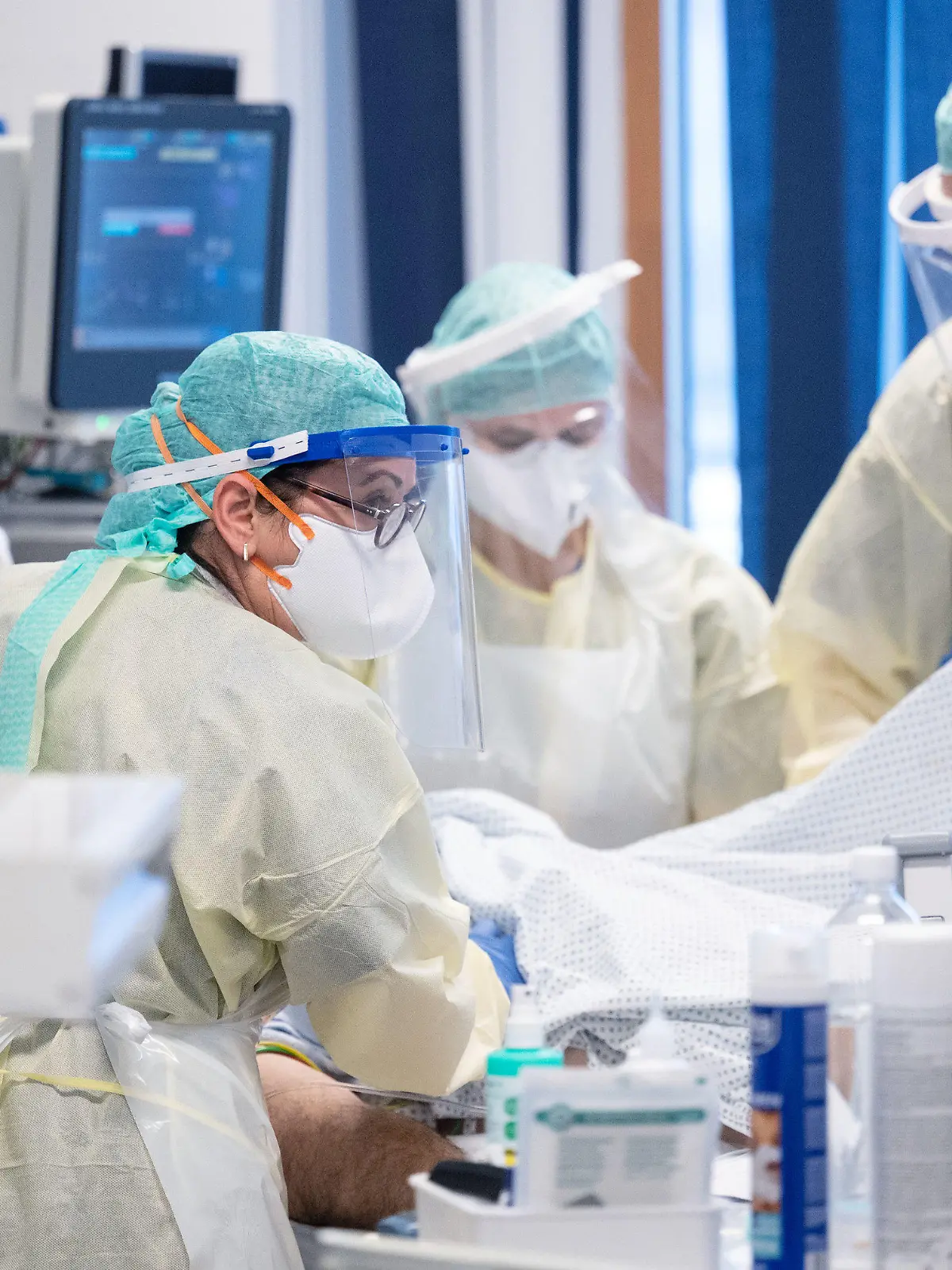 ARCHIV - 11.11.2020, Baden-Württemberg, Stuttgart: Ayse Yeter (l), Krankenschwester und Stationsleitung der Intensivstation für Covid-19 Patienten des Klinikum Stuttgart, versorgt in einem Patientenzimmer einen Covid-19-Patienten, der im künstlichen Koma liegt und beatmet wird. (zu dpa: «Kliniken bei Intensiv-Betten am Limit - Cluster sollen helfen») Foto: Marijan Murat/dpa - ACHTUNG: Nur zur redaktionellen Verwendung im Zusammenhang mit der Berichterstattung über die Intensivpflegerin Ayse Yeter und nur mit vollständiger Nennung des vorstehenden Credits +++ dpa-Bildfunk +++