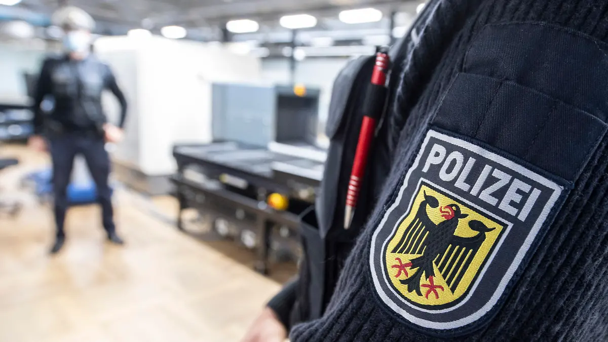 14.12.2020, Hessen, Frankfurt/Main: Beamte der Bundespolizei stehen in der Passagierabfertigung am Flughafen Frankfurt an einem CT-Gepäckscanner. Die Geräte sollen den Inhalt von Fluggepäck innerhalb kürzester Zeit dreidimensional erfassen und Gefahrstoffe weitgehend automatisch erfassen können. (Zu dpa "Bundespolizei testet CT-Gepäckscanner am Flughafen" vom 16.12.20) Foto: Boris Roessler/dpa +++ dpa-Bildfunk +++