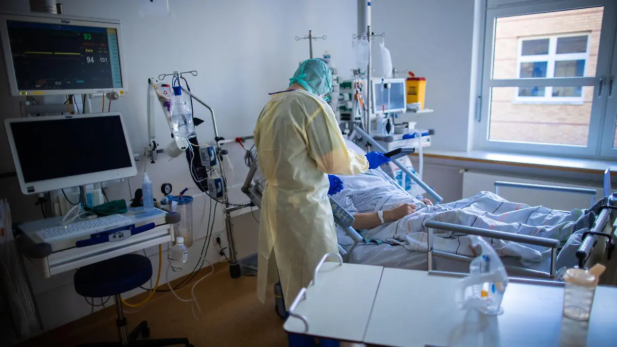 23.11.2020, Mecklenburg-Vorpommern, Greifswald: Ein Mitarbeiter behandelt im besonders geschützten Teil der Intensivstation des Universitätsklinikums Greifswald einen Covid-19-Patienten. Am Universitätsklinikum werden seit Beginn der Pandemie Covid-19-Patienten behandelt. Foto: Jens Büttner/dpa-Zentralbild/dpa +++ dpa-Bildfunk +++