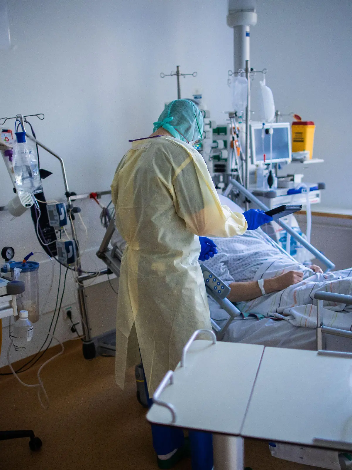 23.11.2020, Mecklenburg-Vorpommern, Greifswald: Ein Mitarbeiter behandelt im besonders geschützten Teil der Intensivstation des Universitätsklinikums Greifswald einen Covid-19-Patienten. Am Universitätsklinikum werden seit Beginn der Pandemie Covid-19-Patienten behandelt. Foto: Jens Büttner/dpa-Zentralbild/dpa +++ dpa-Bildfunk +++