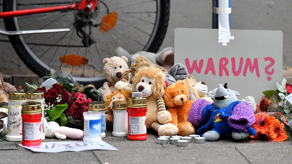 FILE-Teddy bears and candles are pictured at the entrance of an apartment building where five dead children were found in Solingen, Germany, Friday, Sept. 4, 2020. A 28-year-old German mother has been found guilty and sentenced to life in prison for the murder of five of her six children at their home in the western city of Solingen.  (AP Photo/Martin Meissner)