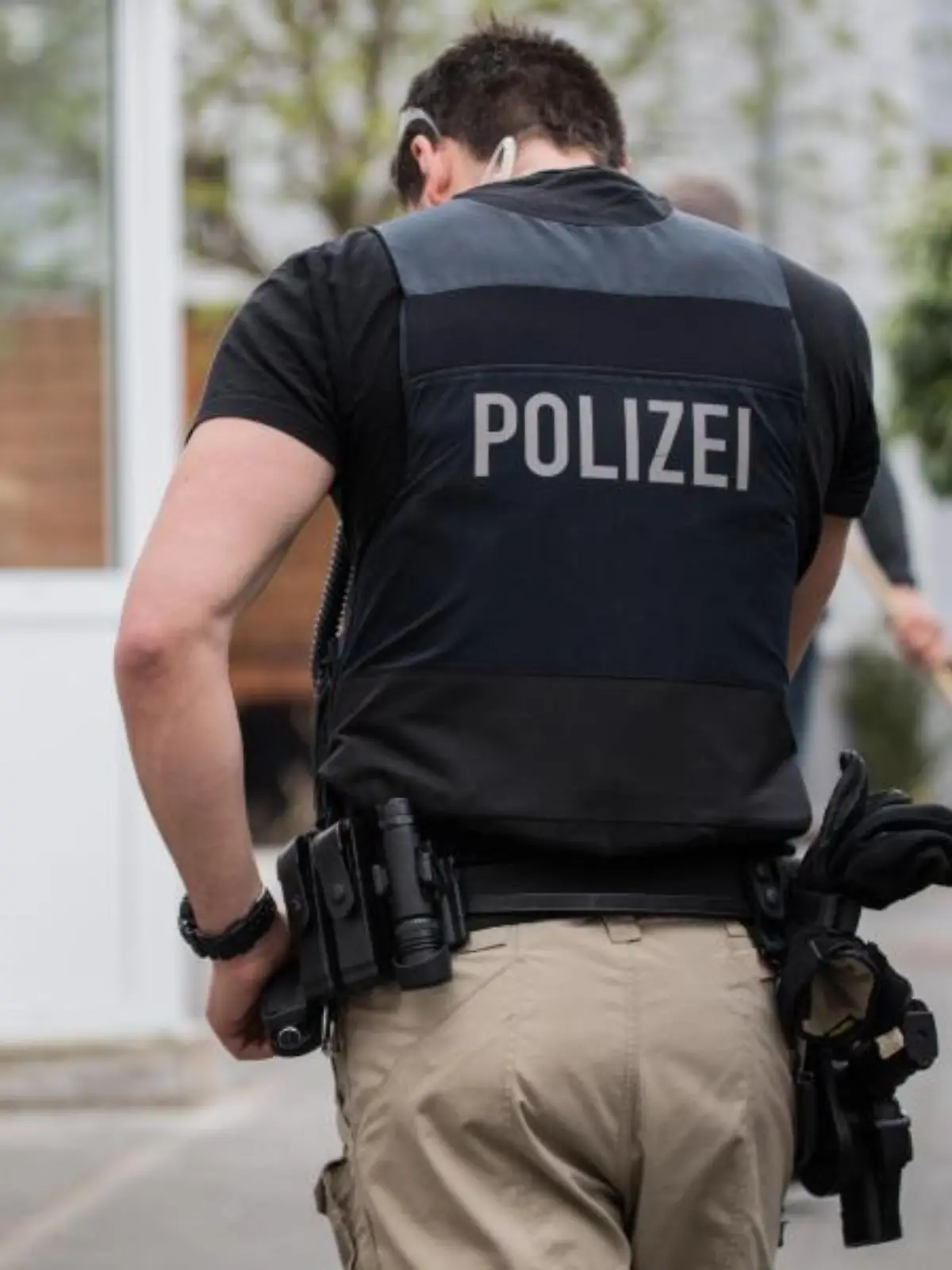 Ein SEK-Beamter steht im Zugang zu einem Grundstück