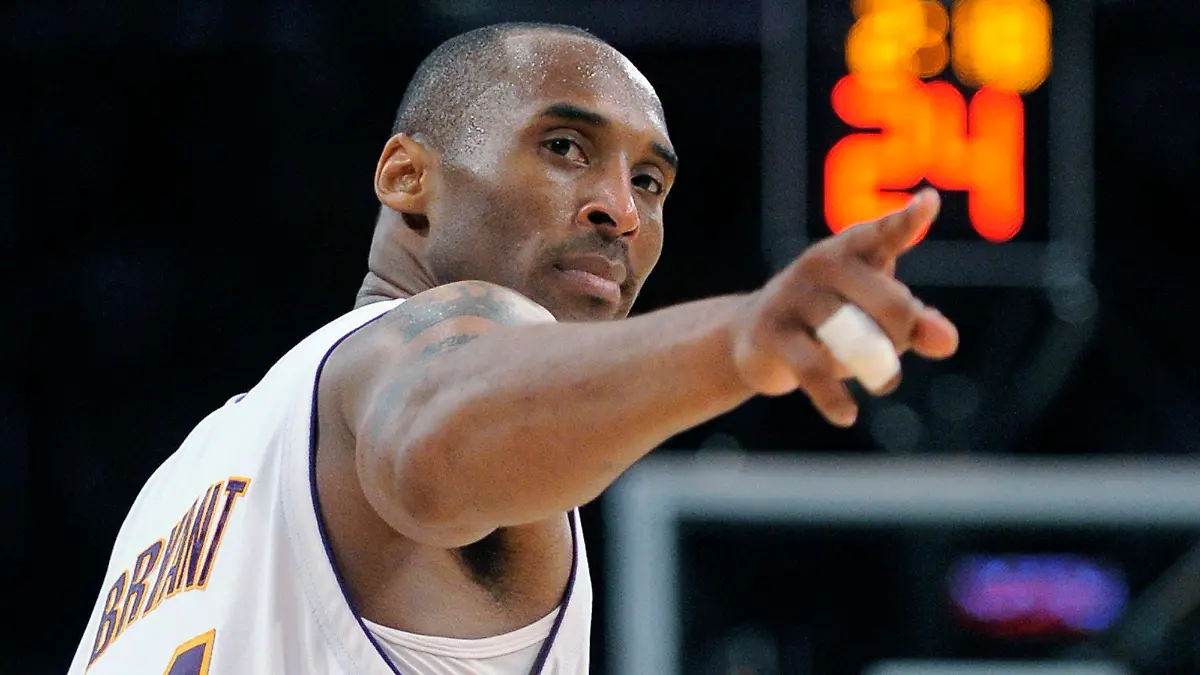FILE - In this June 7, 2009, file photo, Los Angeles Lakers guard Kobe Bryant (24) points to a player behind him after making a basket in the closing seconds against the Orlando Magic in Game 2 of the NBA basketball finals in Los Angeles. Federal safety officials are expected to vote Tuesday, Feb. 9, 2021, on what likely caused the helicopter carrying Kobe Bryant, his 13-year-old daughter and seven others to crash into a Southern California hillside last year, killing all aboard. (AP Photo/Mark J. Terrill, file)