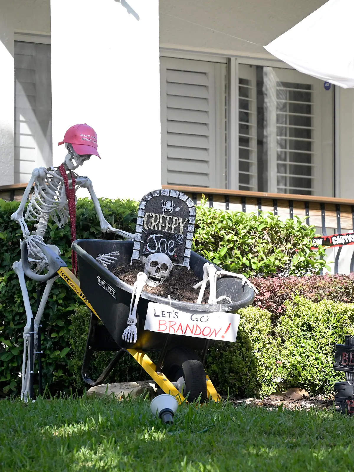A Halloween display incorporating a Make America Great Again hat, a Creepy Joe headstone and a Let's Go Brandon sign is viewed outside a home during a new coronavirus pandemic, Wednesday, Oct. 27, 2021, in Orlando, Fla. (AP Photo/Phelan M. Ebenhack)