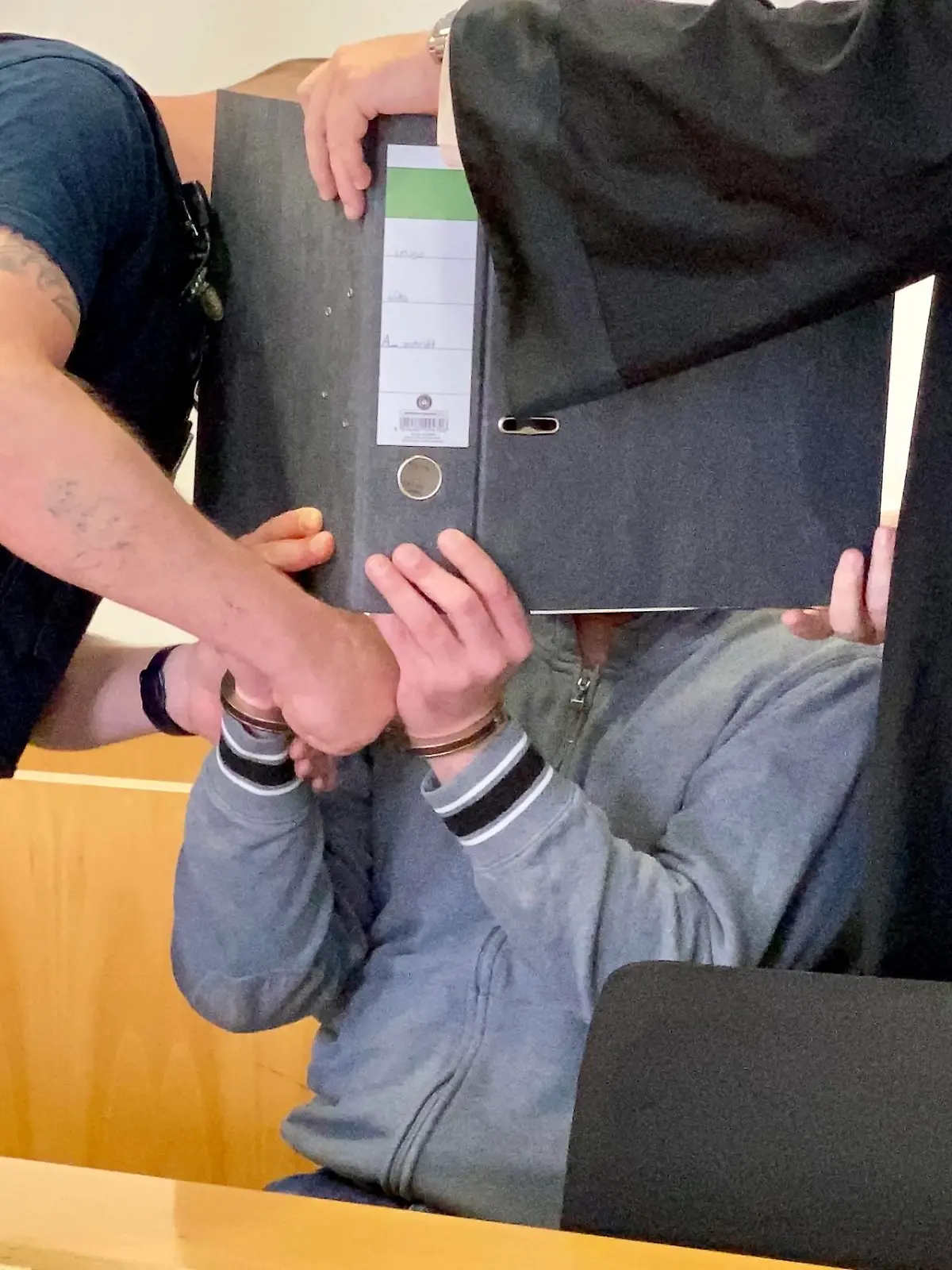 Mordprozess in Hanau: Der Angeklagte Ingo K. hat sich zum Prozessauftakt hinter einem Aktenordner versteckt.