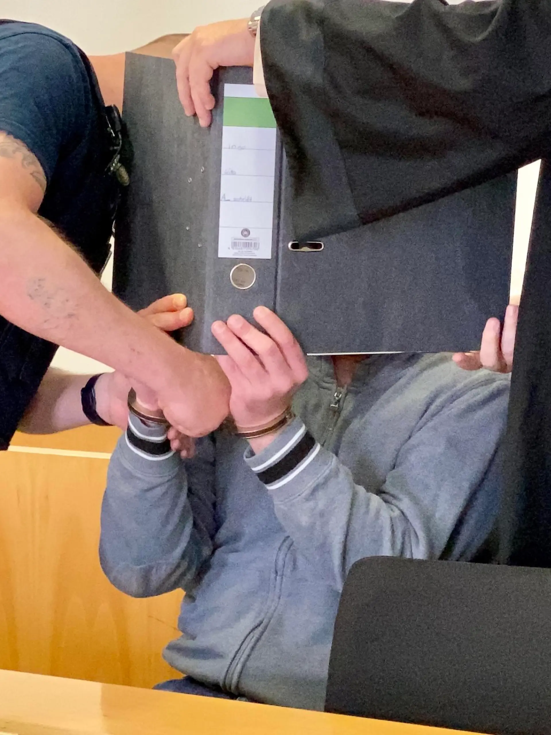 Mordprozess in Hanau: Der Angeklagte Ingo K. hat sich zum Prozessauftakt hinter einem Aktenordner versteckt.