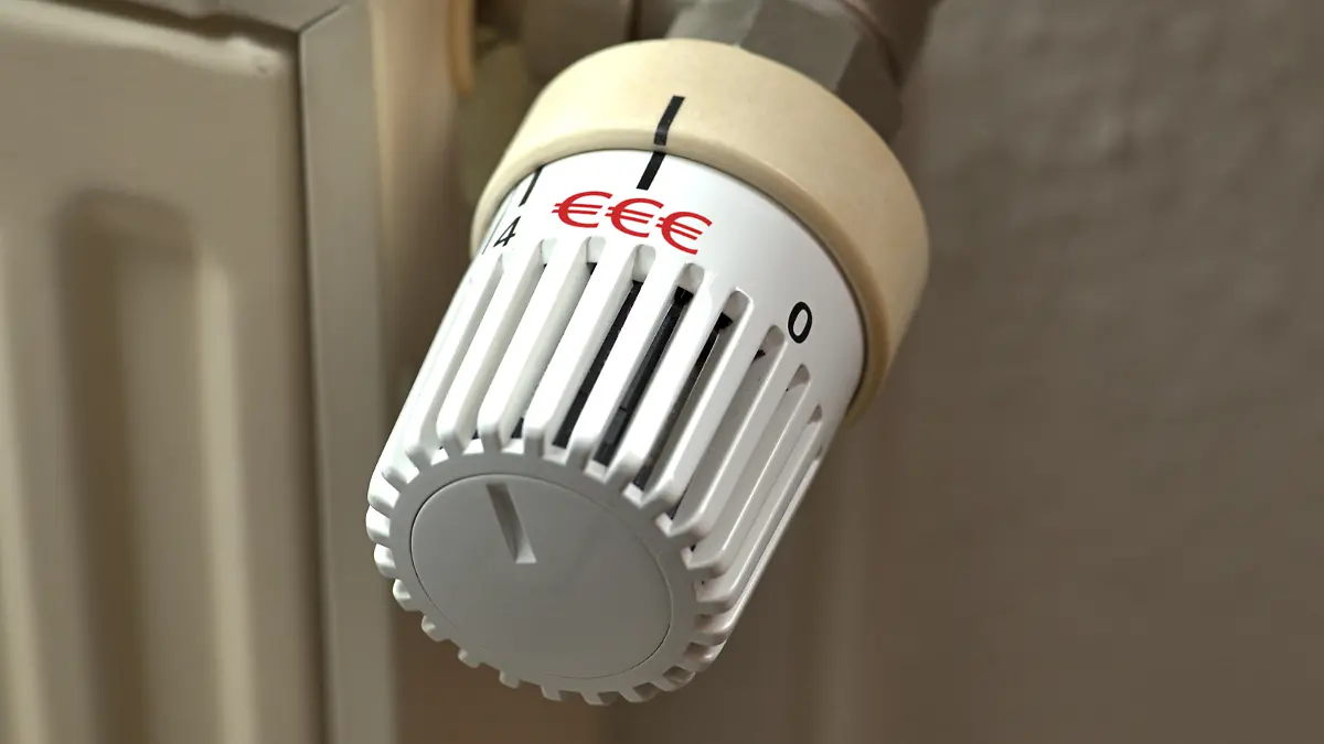 Ein manuelles Thermostat an einem Heizkörper mit drei roten Euro-Zeichenals Aufdruck. Symbolbild in Bezug auf die stark steigenden Energiepreise [M].